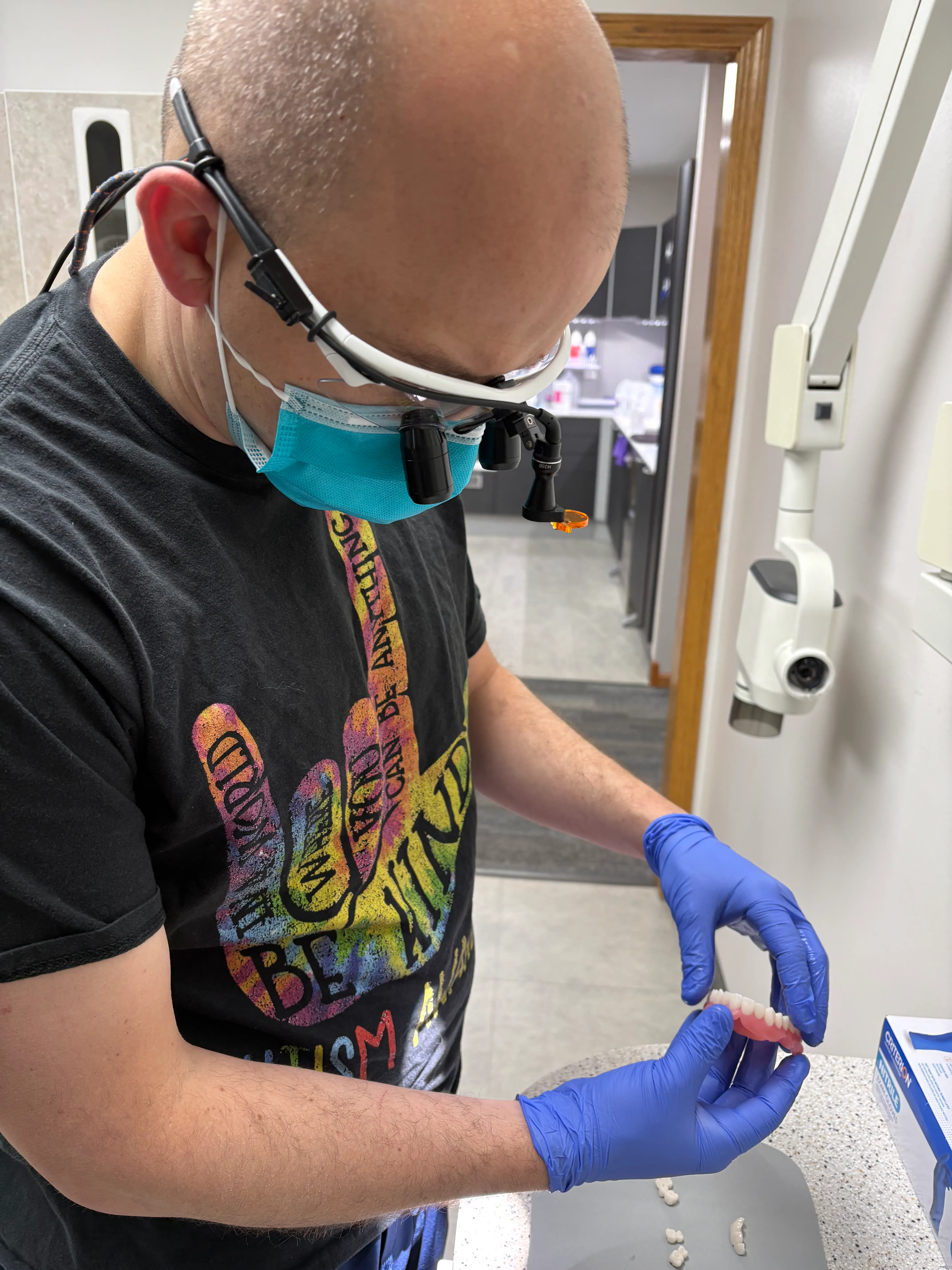 Clinician inspecting a custom-made dental crown in the operatory