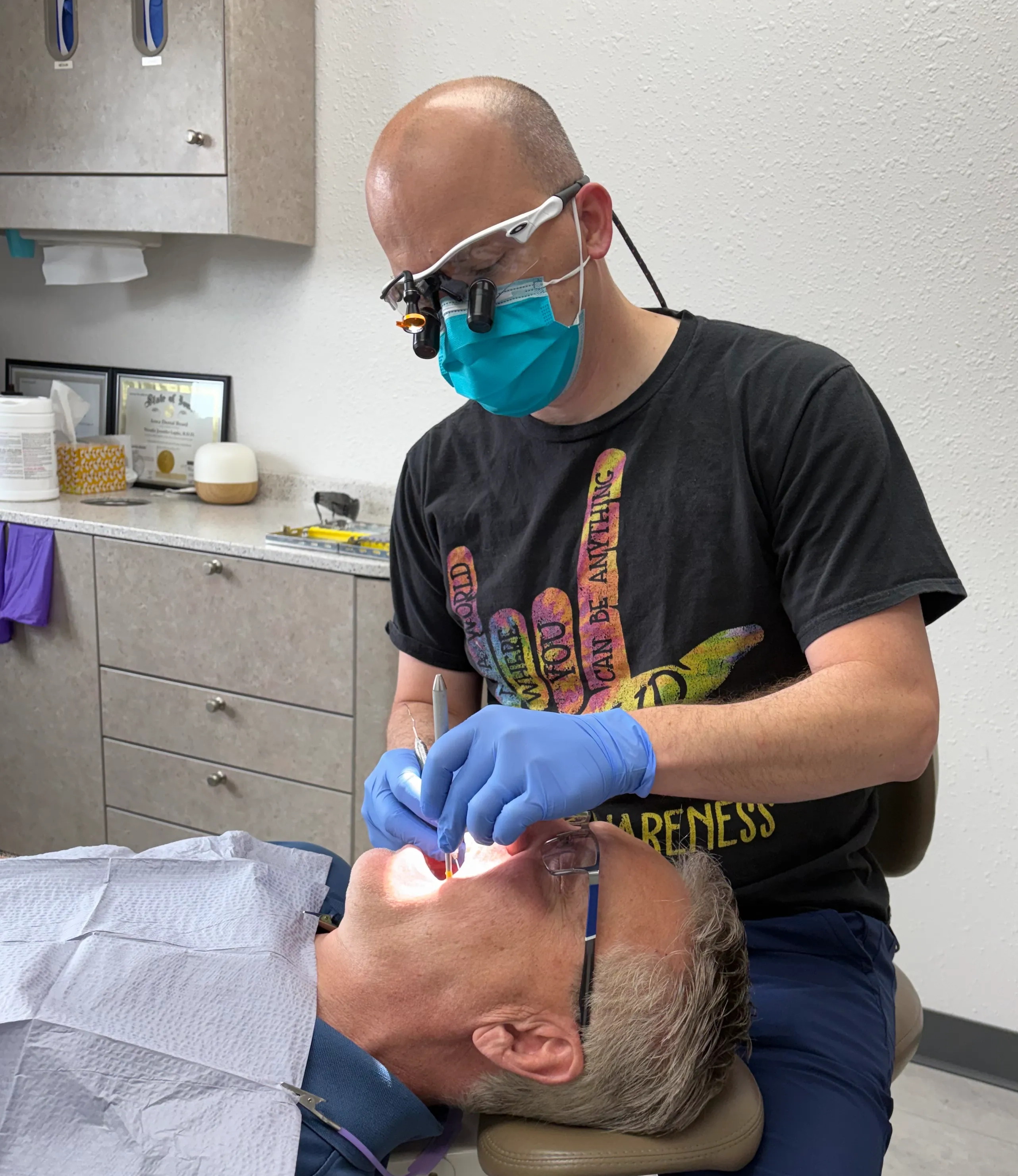 Dental team member examining a patient's open mouth