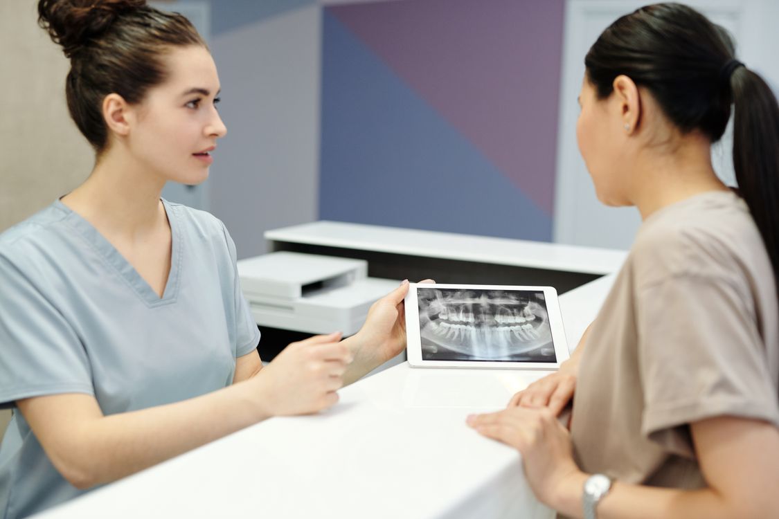 Dentist reviewing a dental X-ray with a patient during a consultation