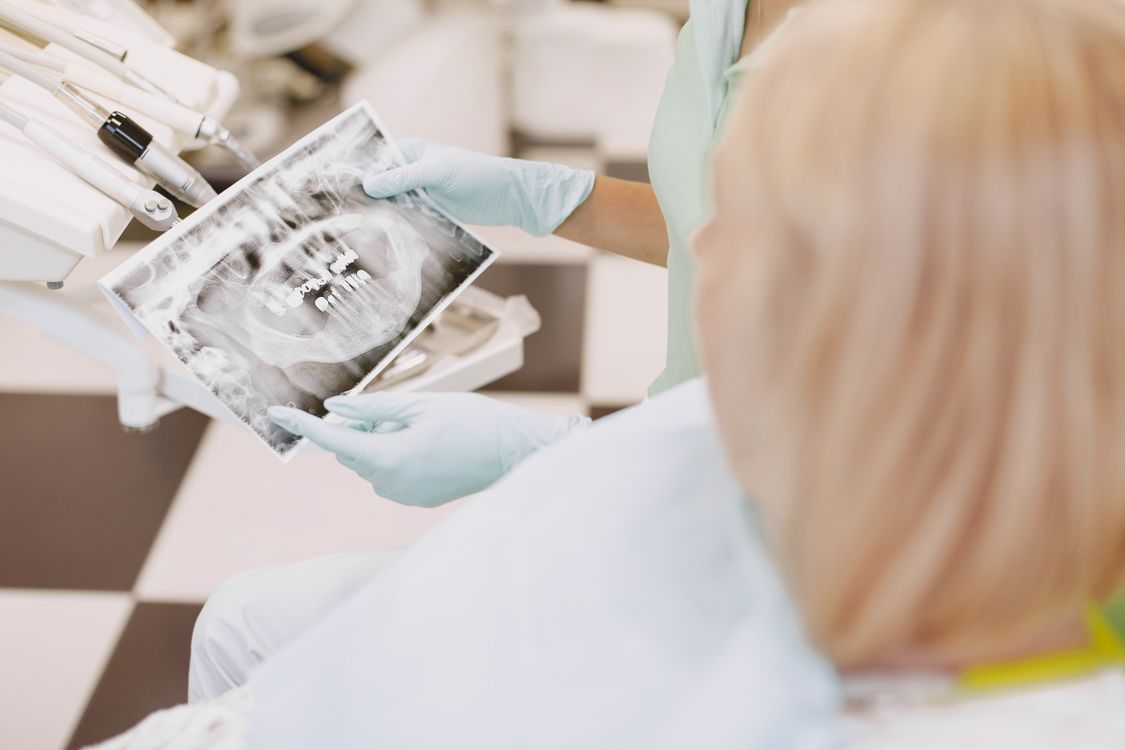 Dentist showing a patient a dental X-ray during a treatment discussion