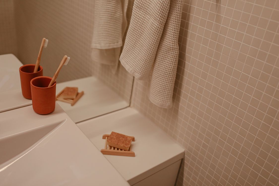 Modern toothbrushes standing beside soap in a clean bathroom