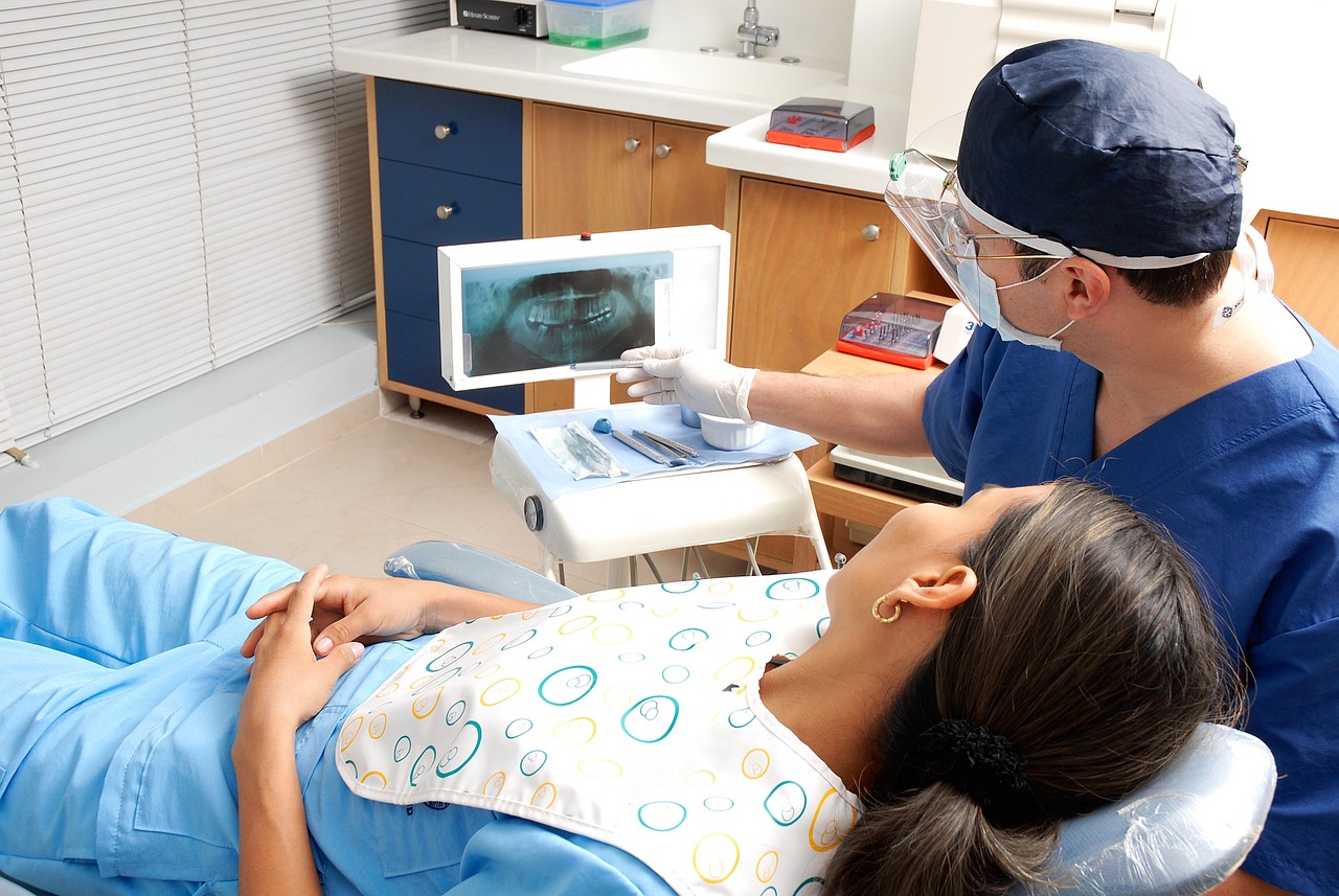 Dentist reviewing a panoramic dental X-ray with a patient in the dental chair