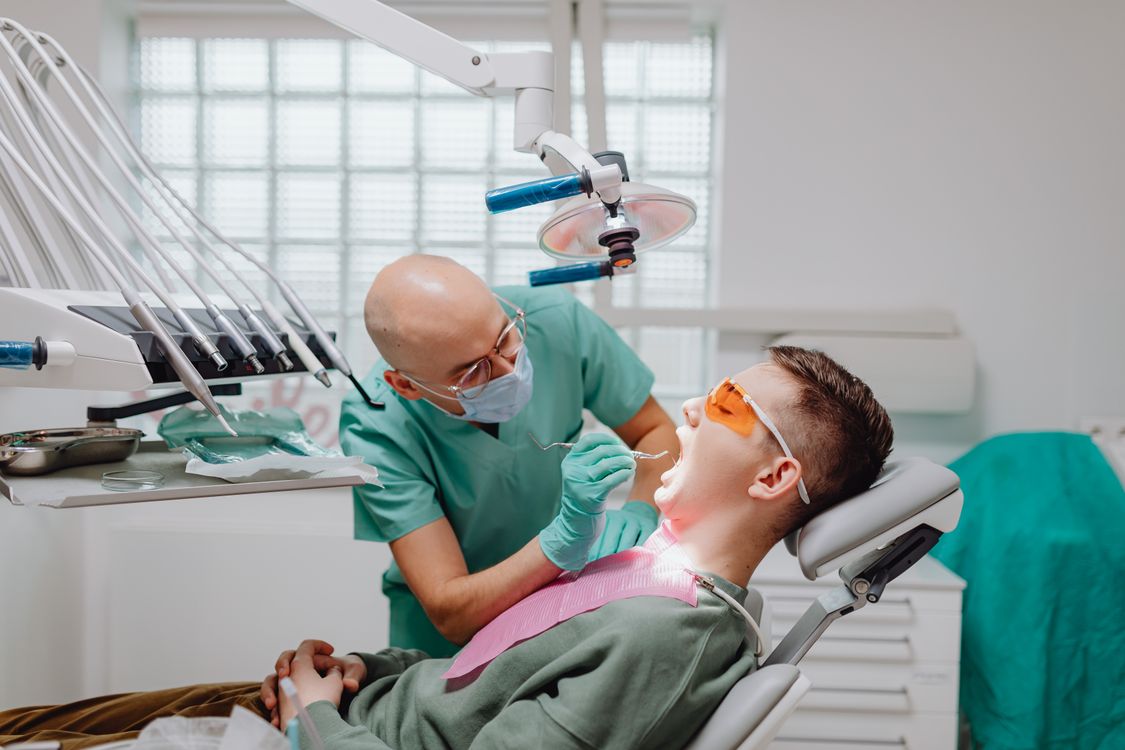 Dentist performing an oral examination during a preventive dental visit