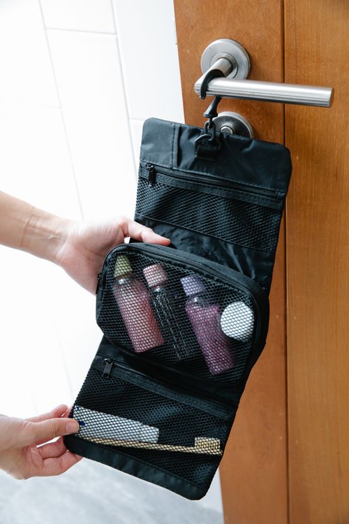 Travel toiletry bag containing a toothbrush and hygiene essentials for vacation