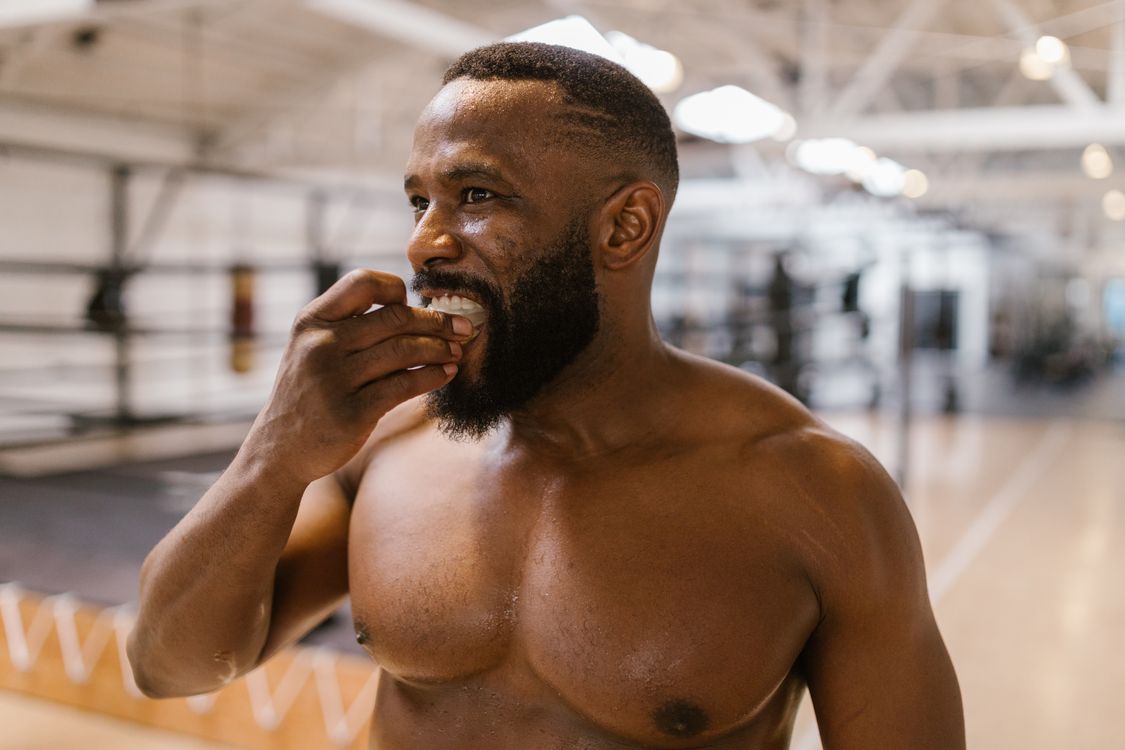 Athlete putting in a mouthguard before training to protect the teeth