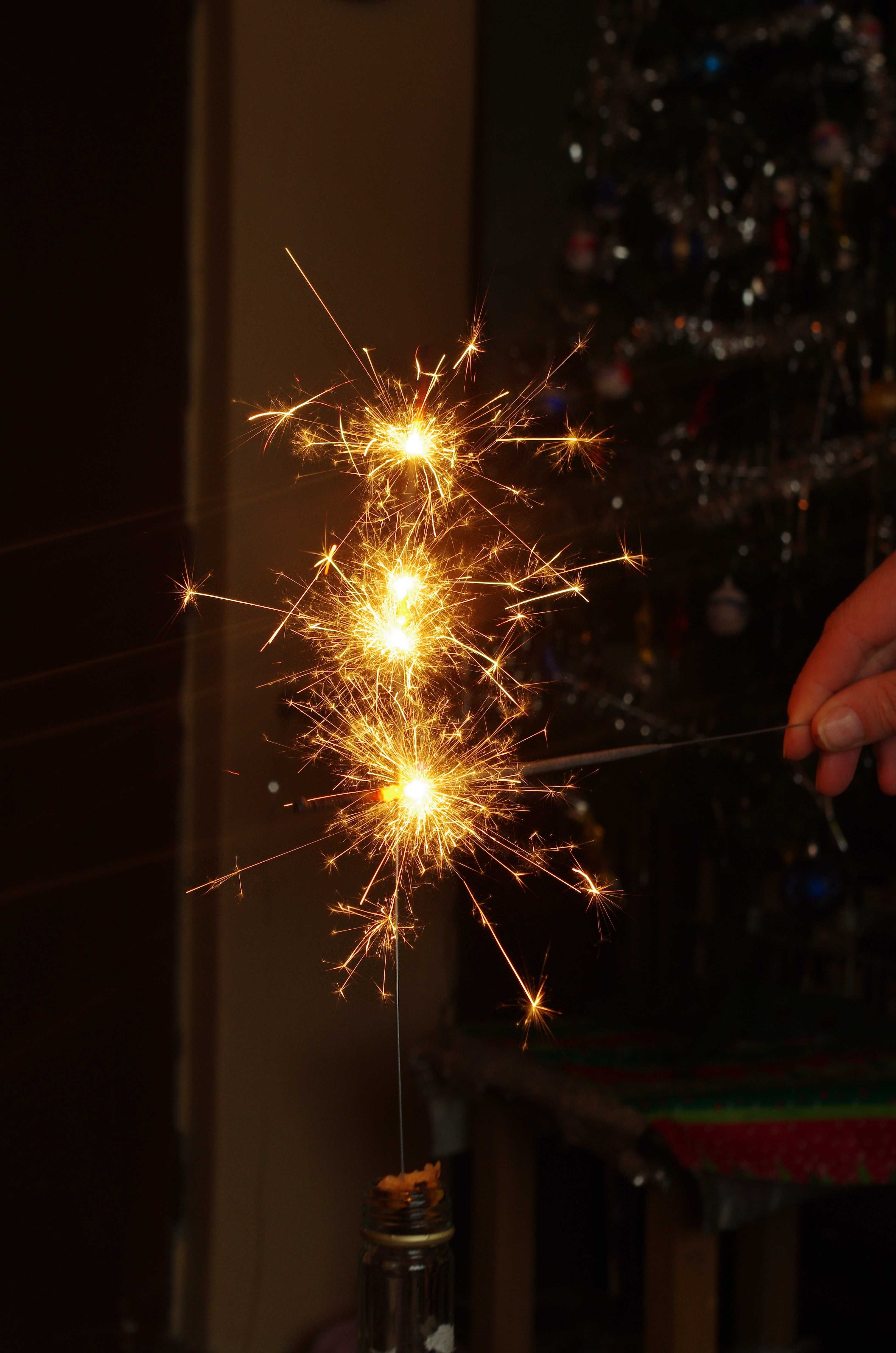 Sparklers lit against the night sky during a New Year's Eve celebration