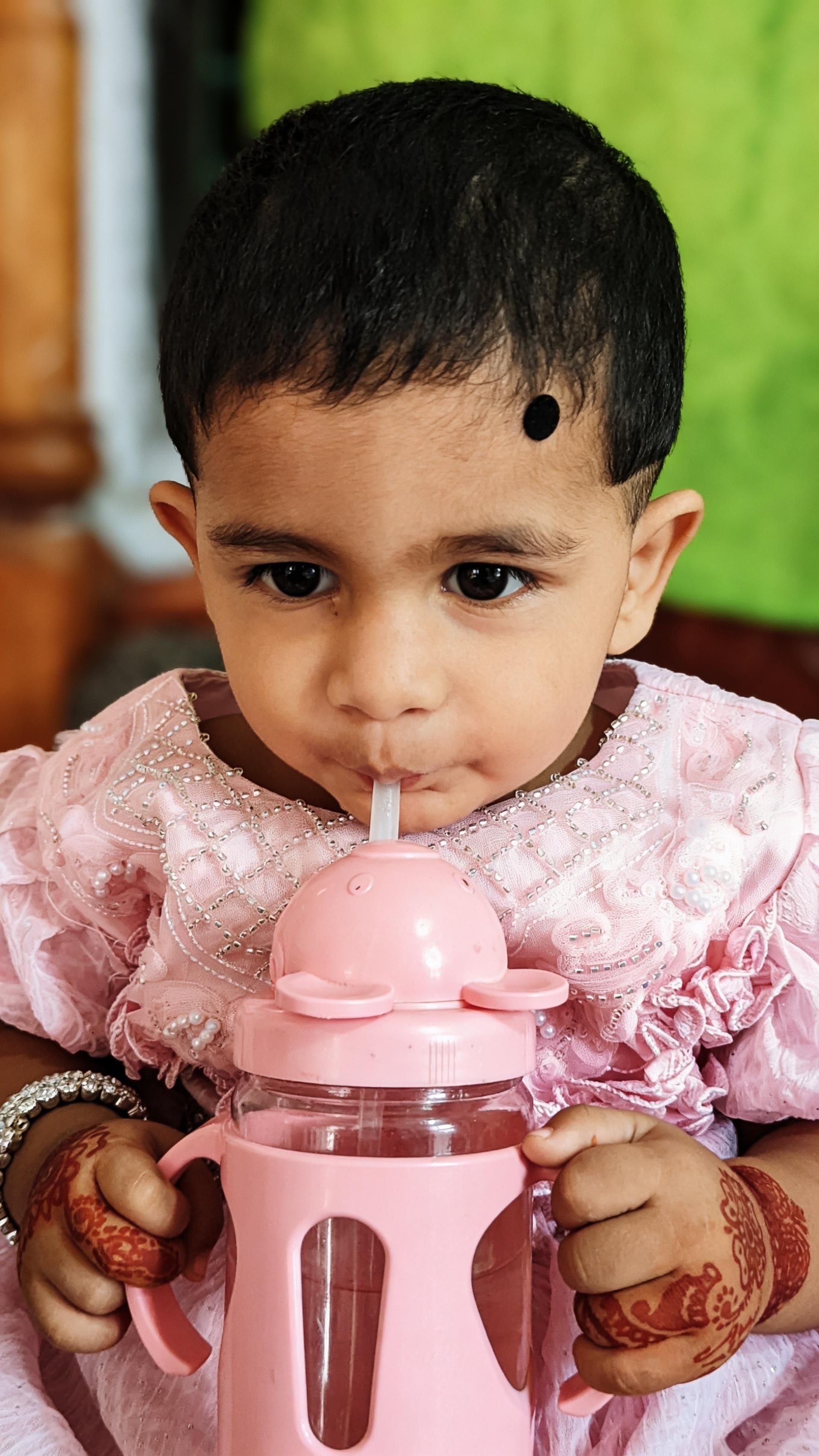Toddler drinking from a small cup at home