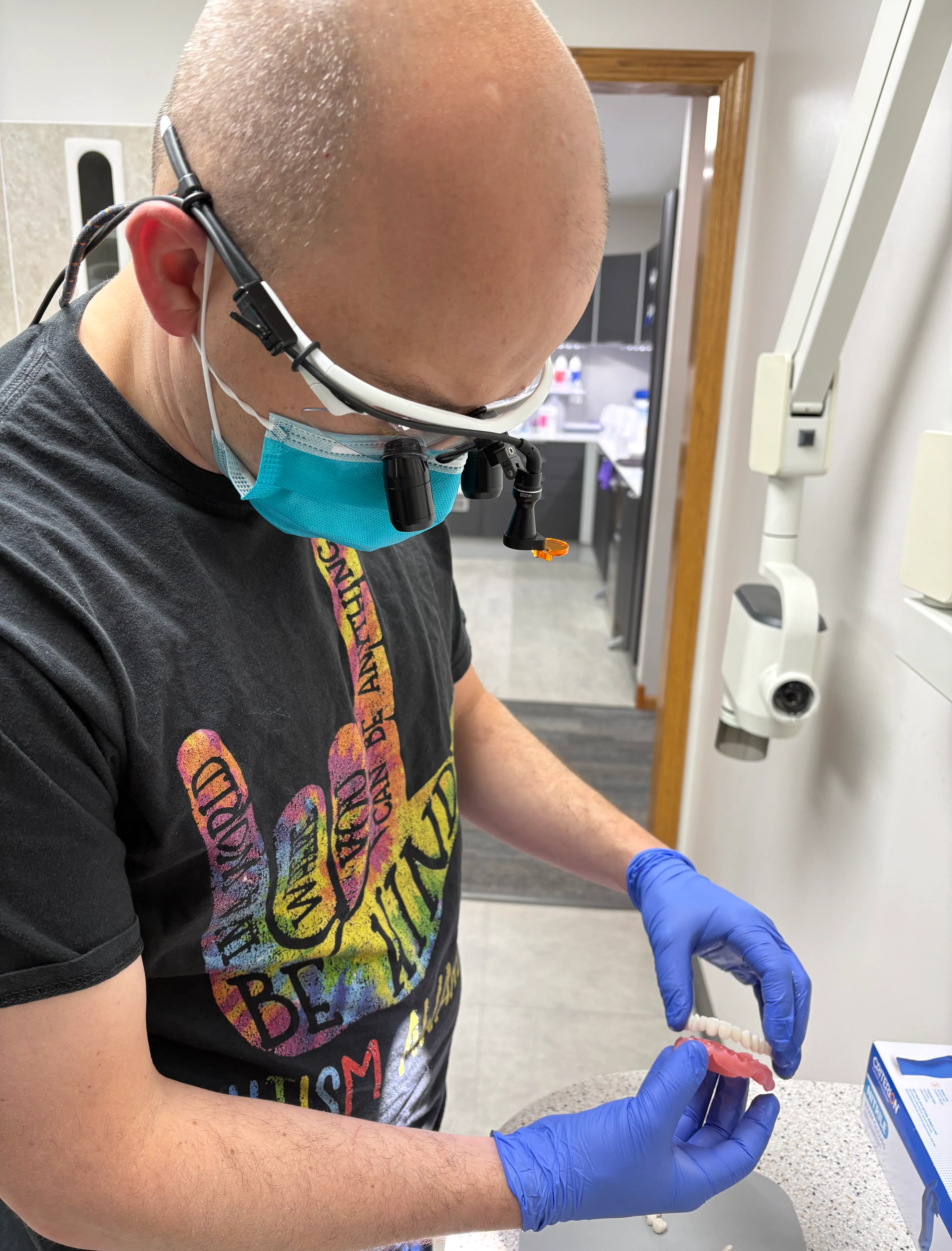 Clinician examining a custom dental restoration on a model
