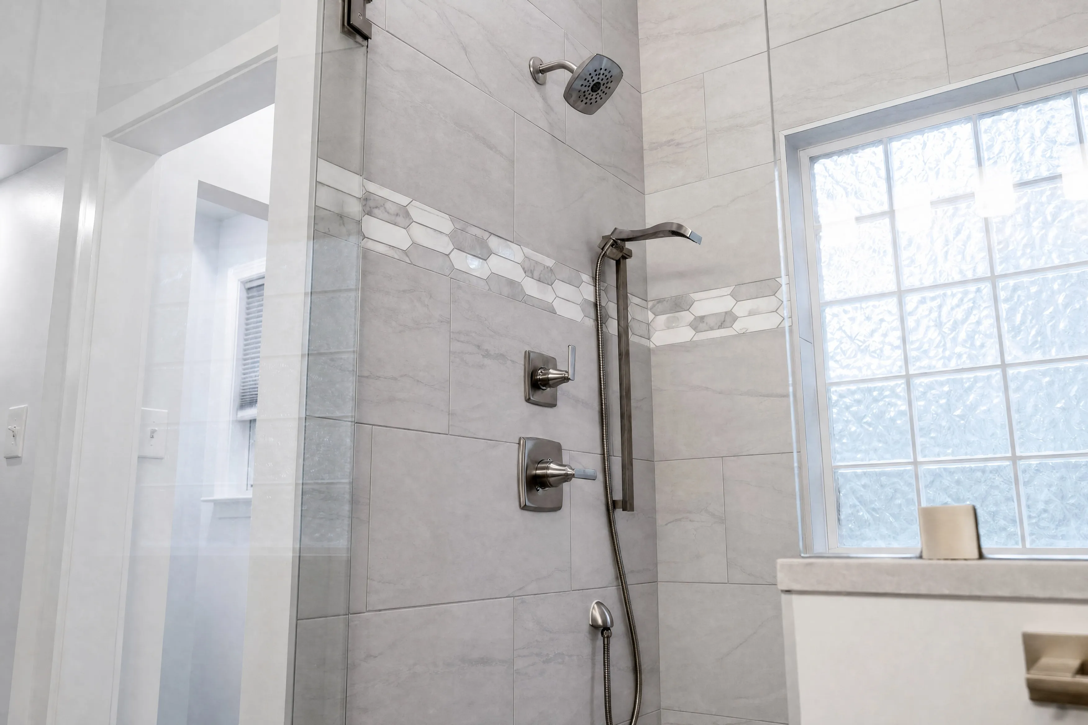 Walk-in shower with mosaic tile band and bronze fixtures, Peachtree City