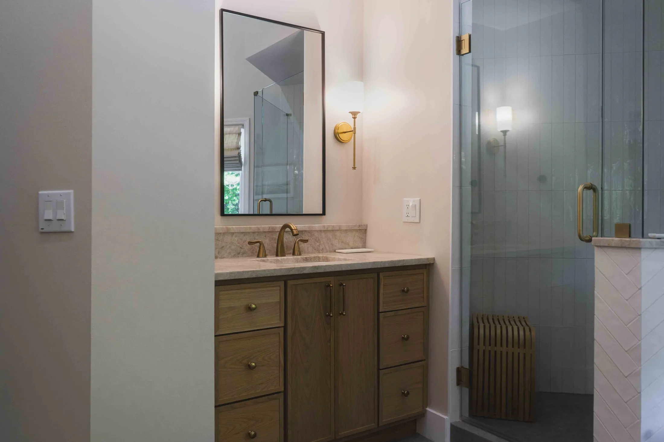 Master bathroom vanity beside a glass shower enclosure