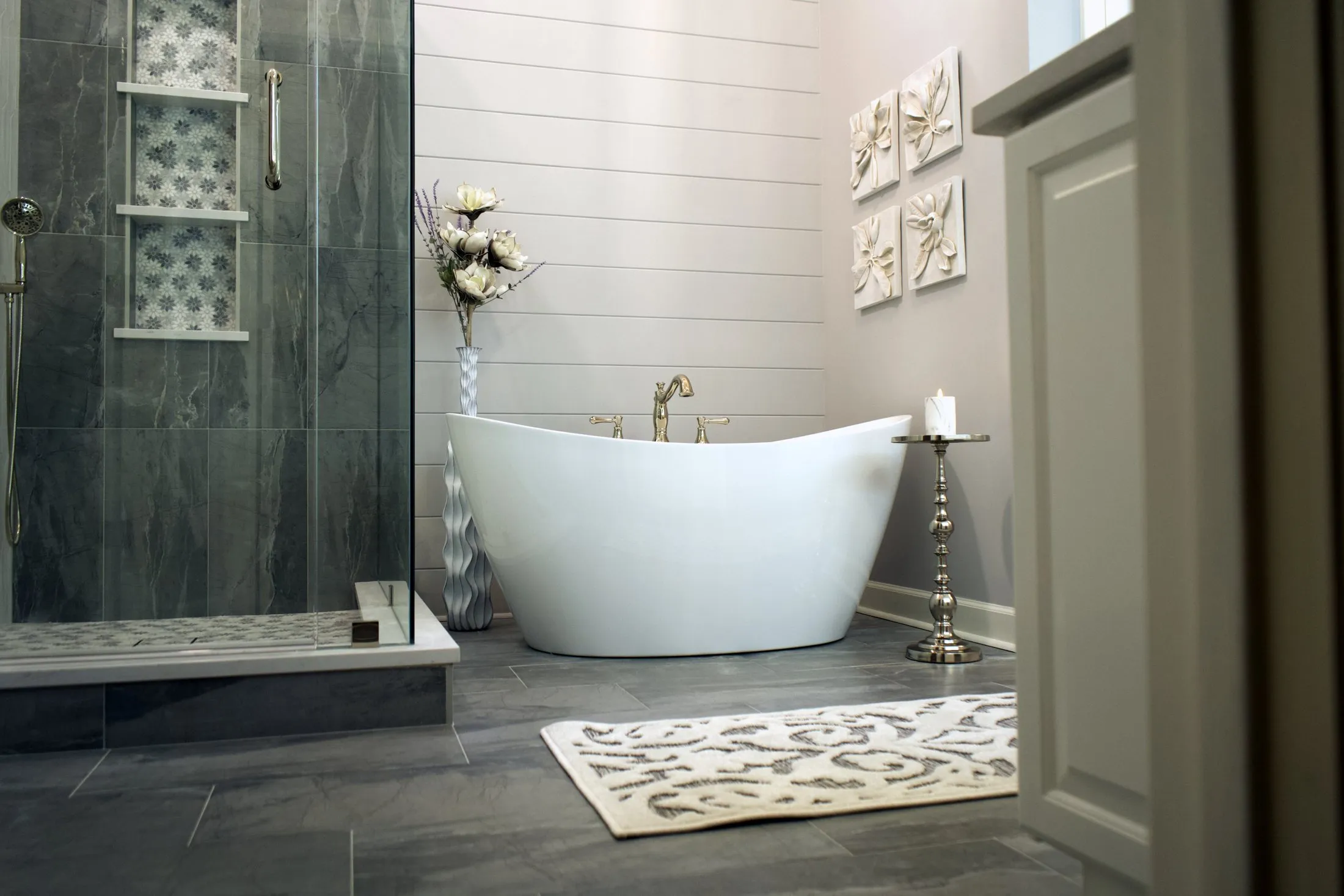 Master bathroom with a freestanding tub, slate-look tile and a tiled shower niche