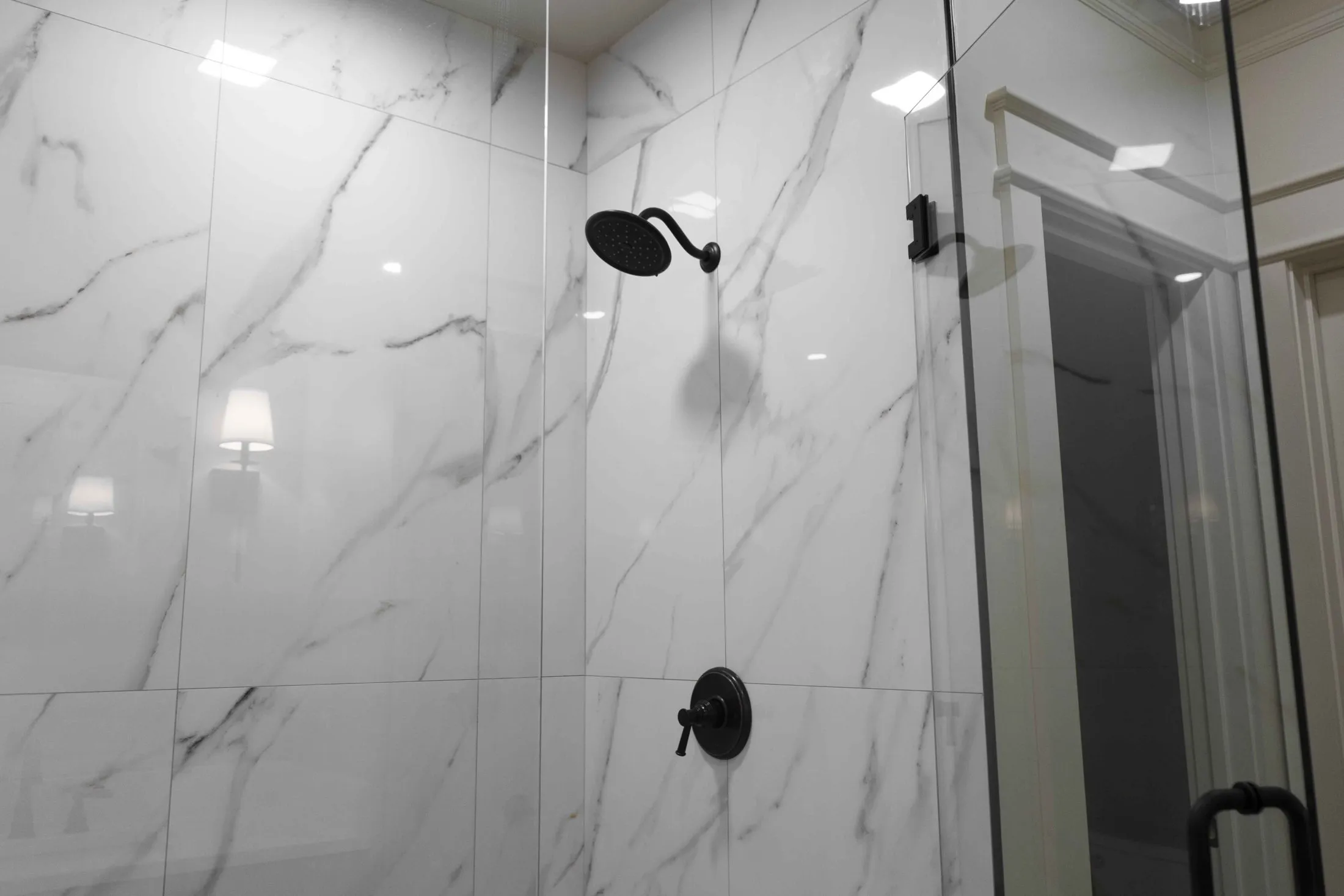 Marble-look walk-in shower with matte black fixtures