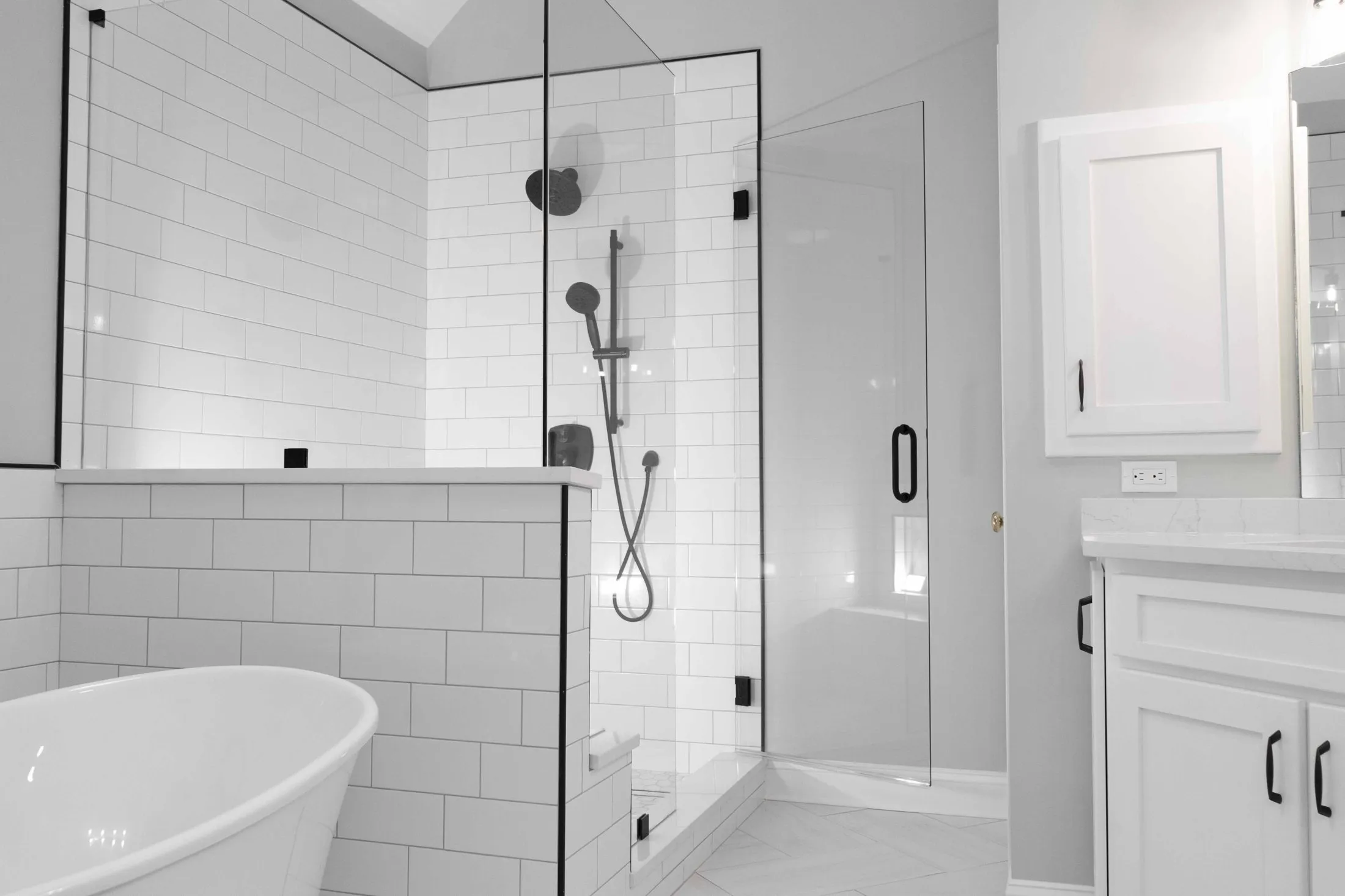 White subway tile shower beside a freestanding tub