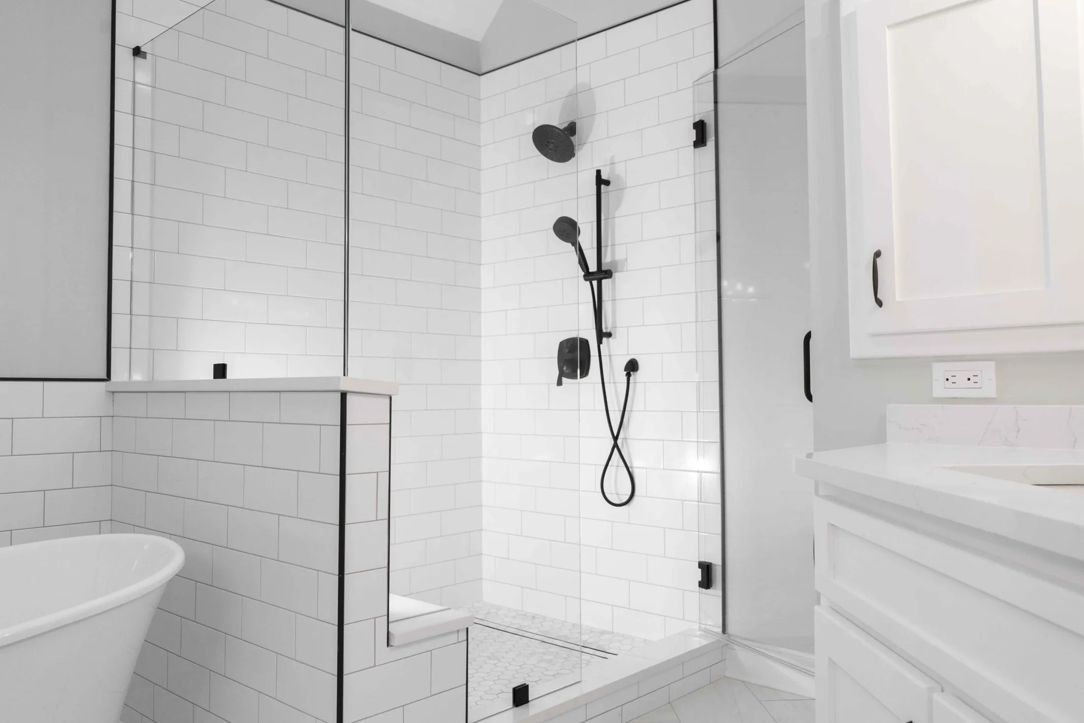 Walk-in shower in white subway tile with matte black fixtures