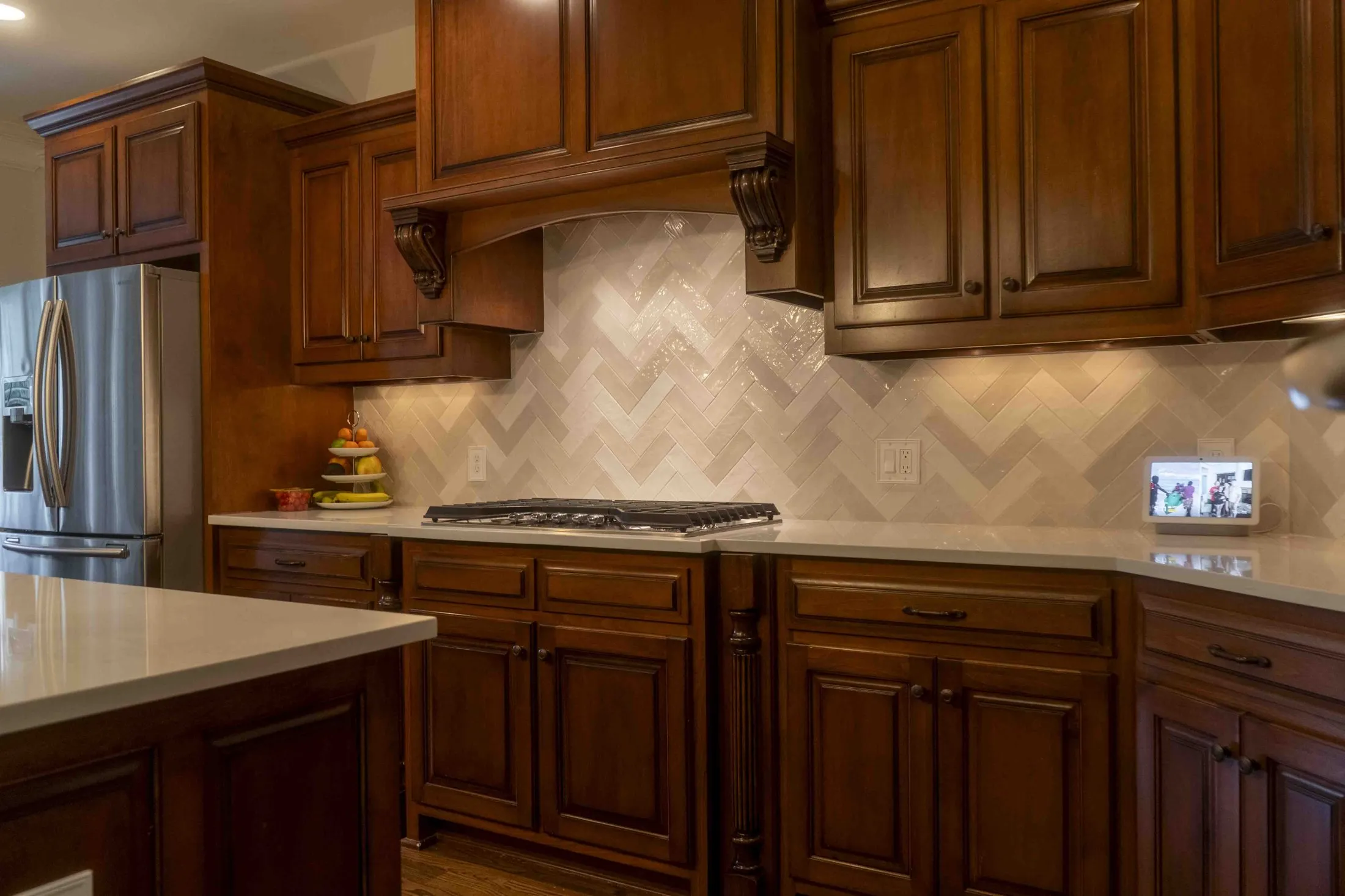 Herringbone tile backsplash behind a gas range