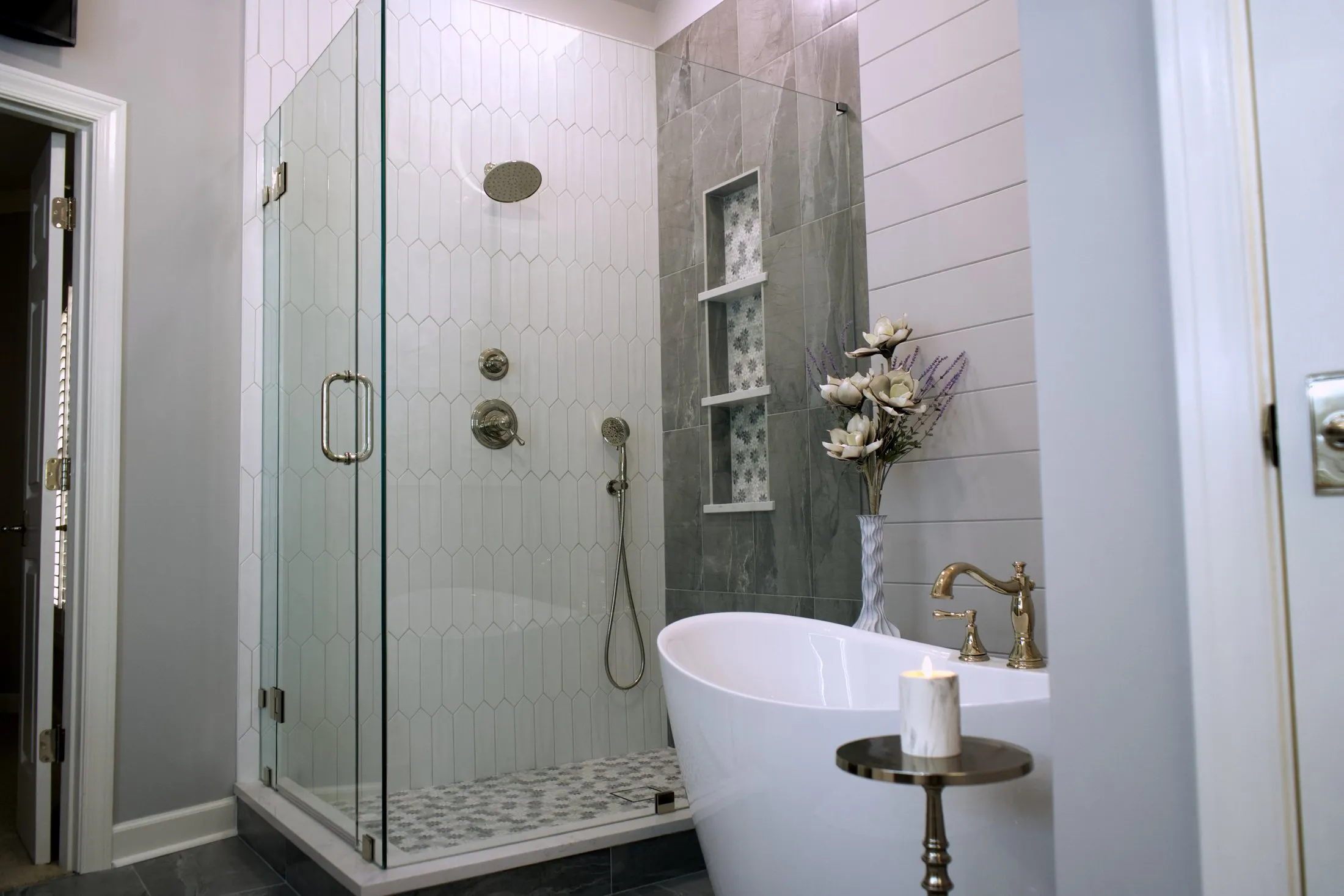 Corner shower in slate-look tile beside a freestanding tub