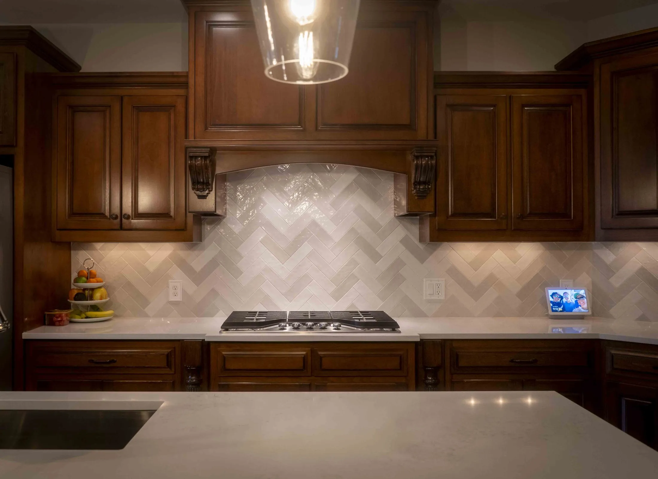 Kitchen counter and herringbone backsplash under cabinet lighting