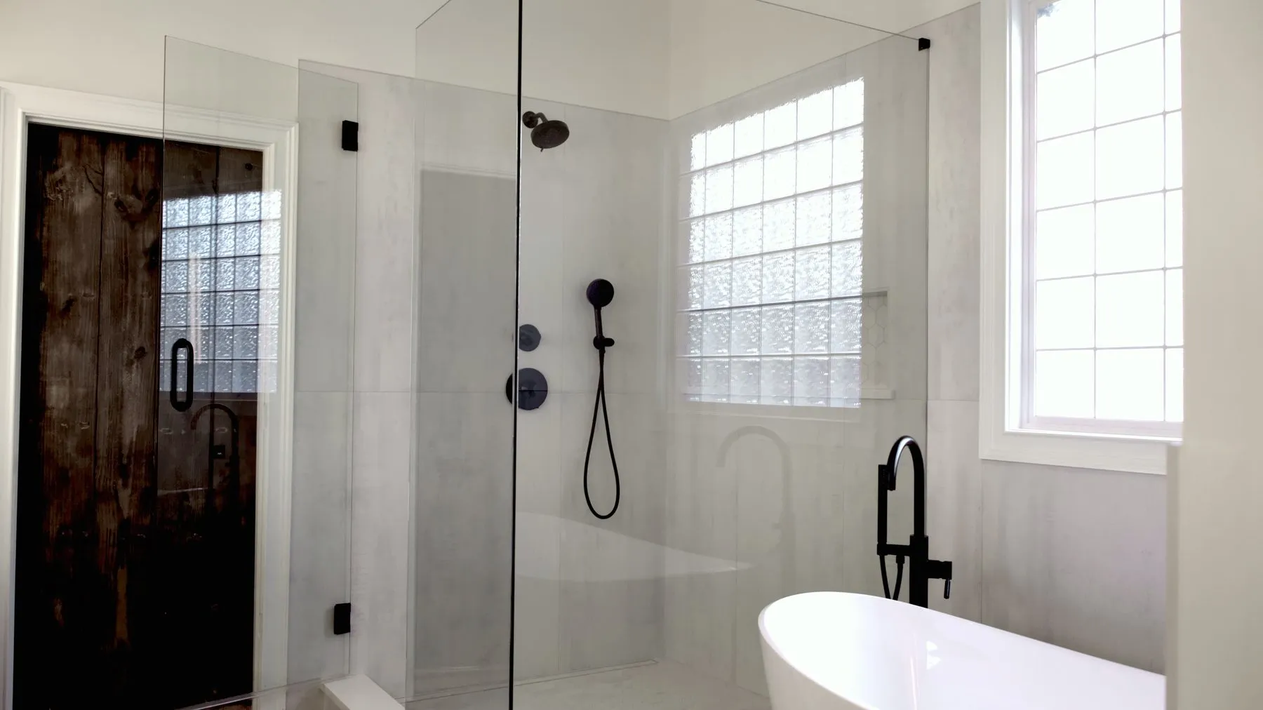 Master bathroom remodel with a frameless glass walk-in shower, freestanding tub and large-format porcelain tile