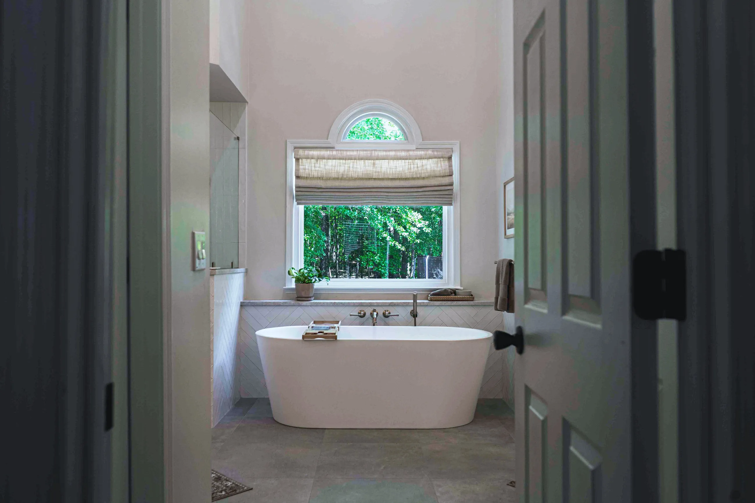 Master bathroom with a freestanding tub under an arched window, Peachtree City