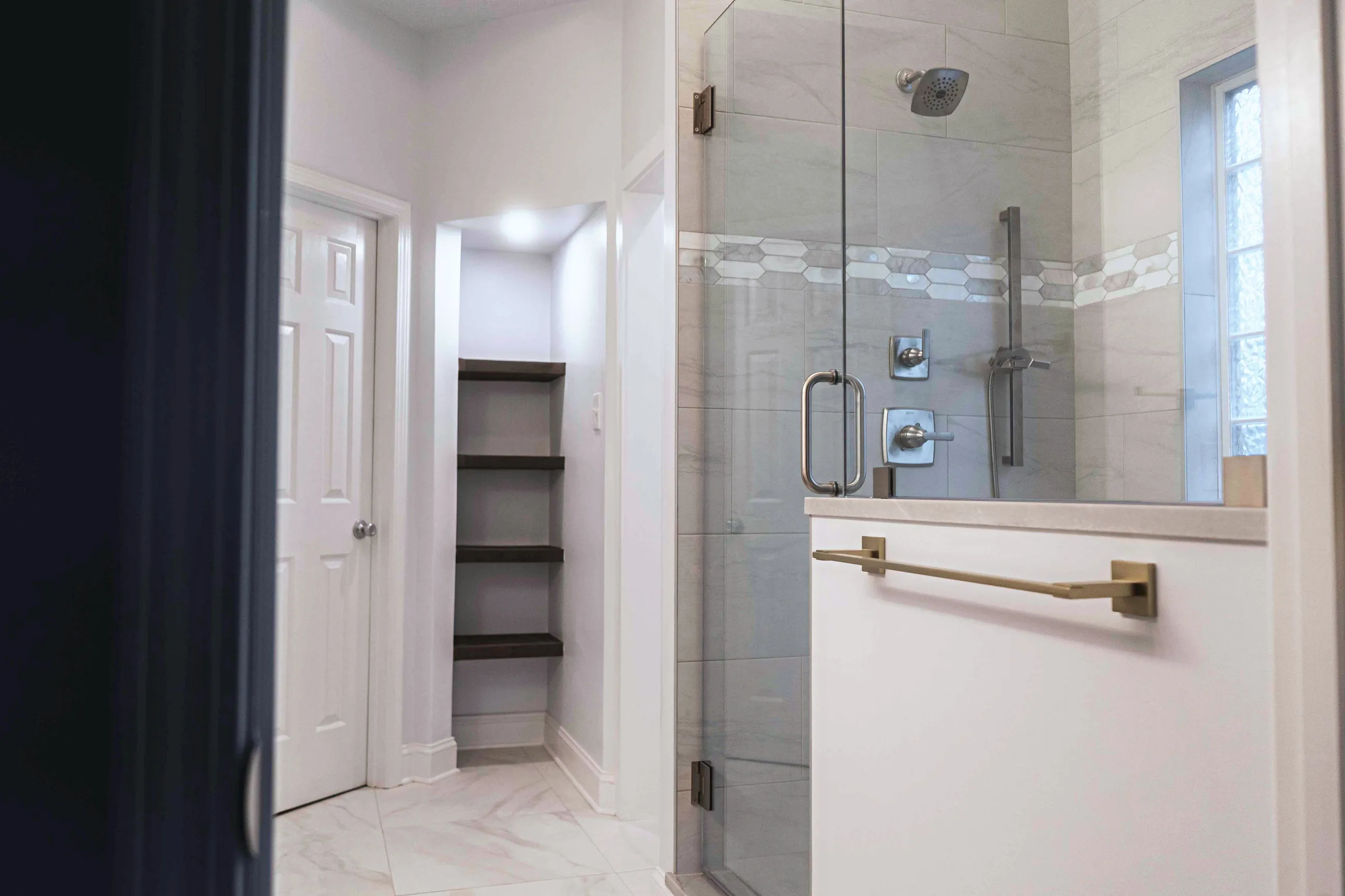 Walk-in shower with mosaic tile border and built-in bench