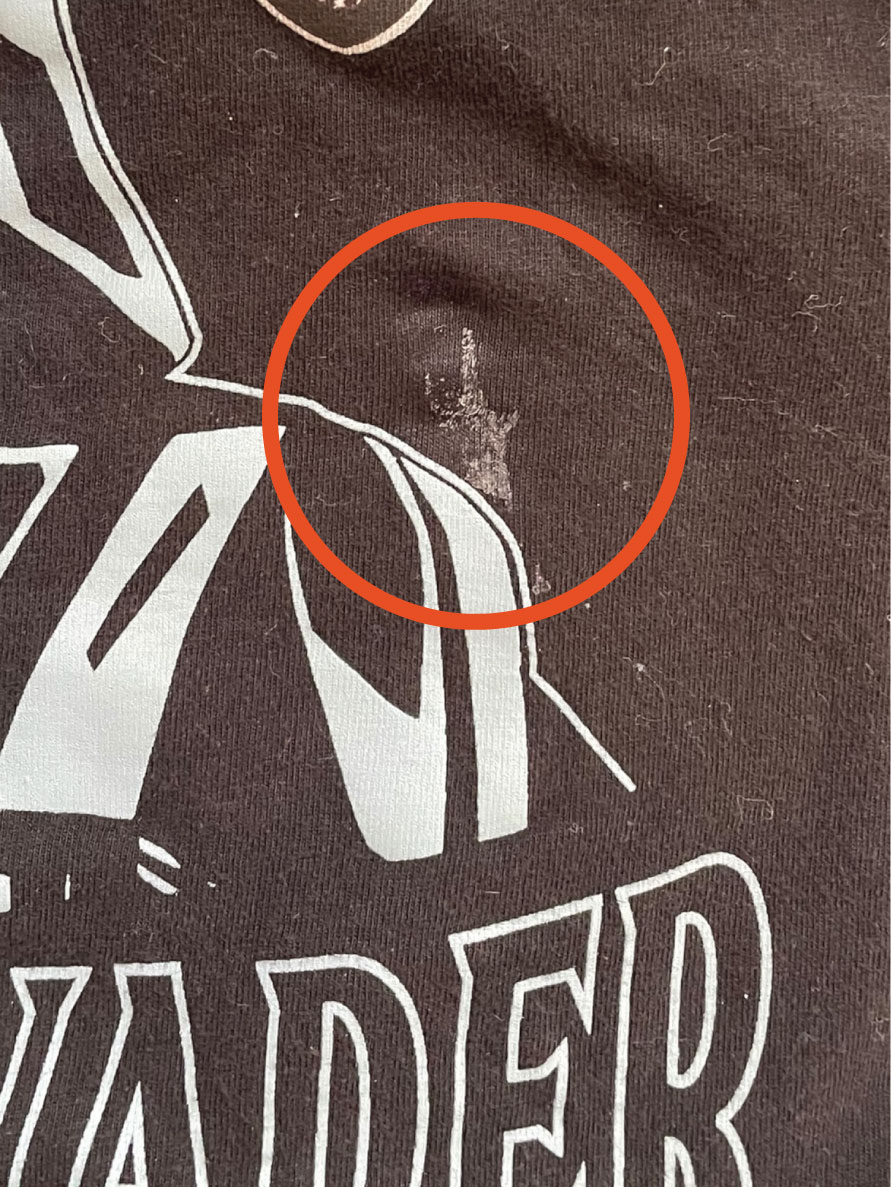 Black t-shirt with a pale stain, circled