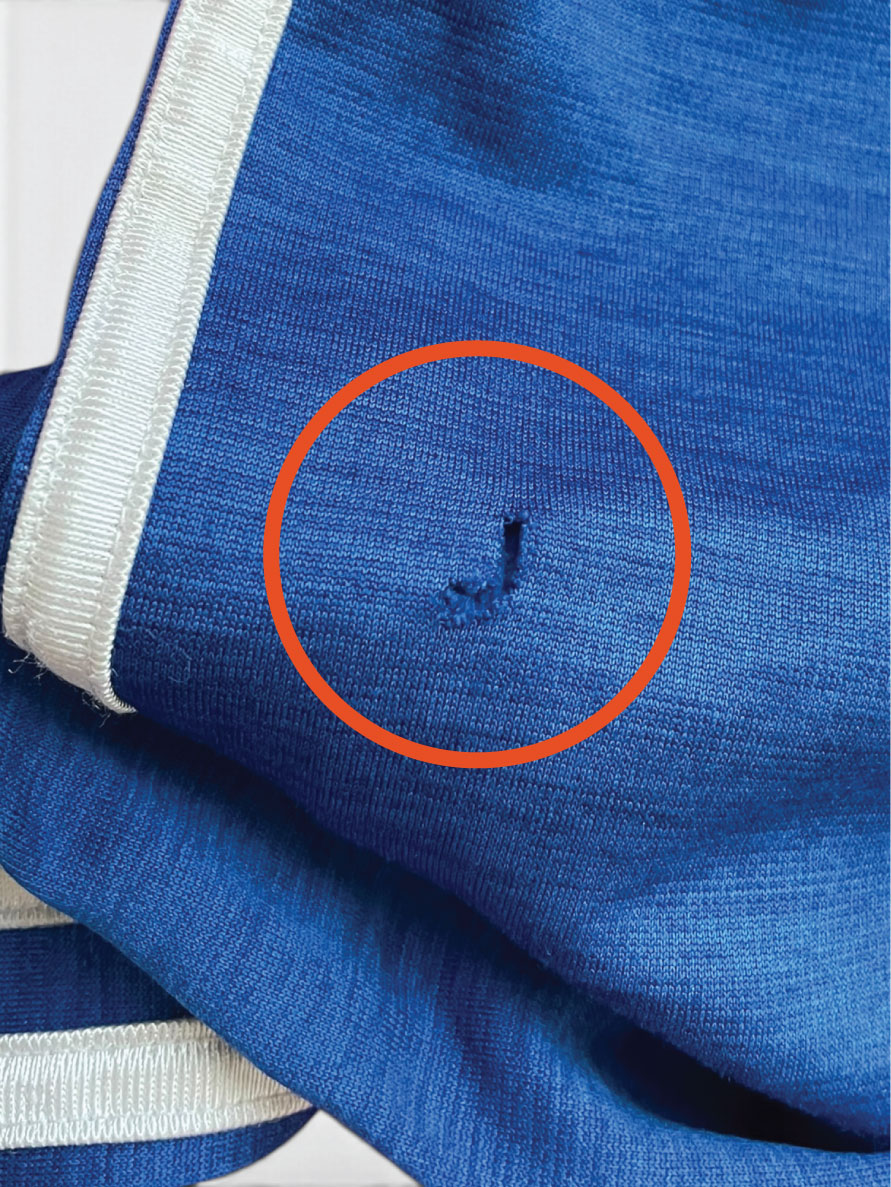 Blue knit shirt with a small hole, circled