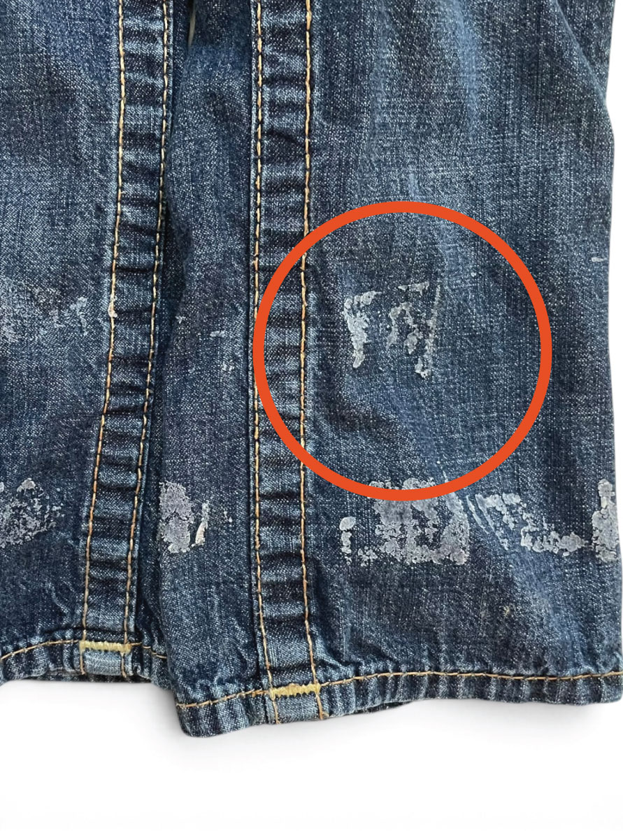 Jeans with hem tape glue left on the denim, circled