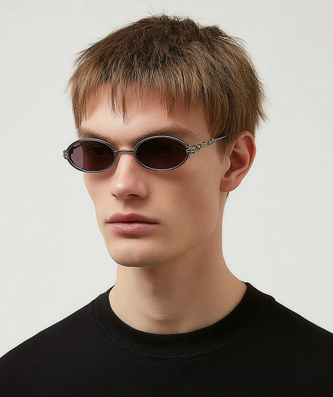 A young man wearing sunglasses and a black t - shirt.