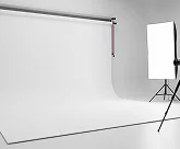 A white room with a white screen and a tripod.
