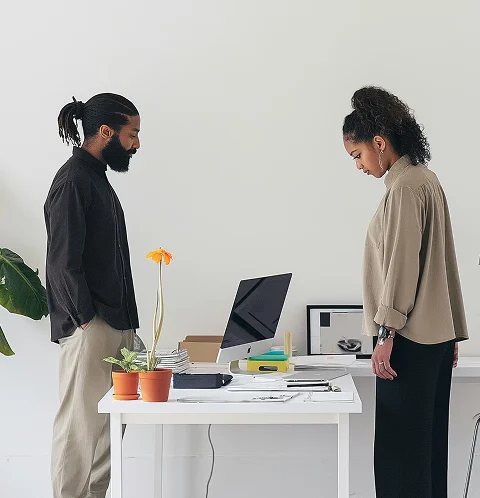 A man and a woman standing at a desk.