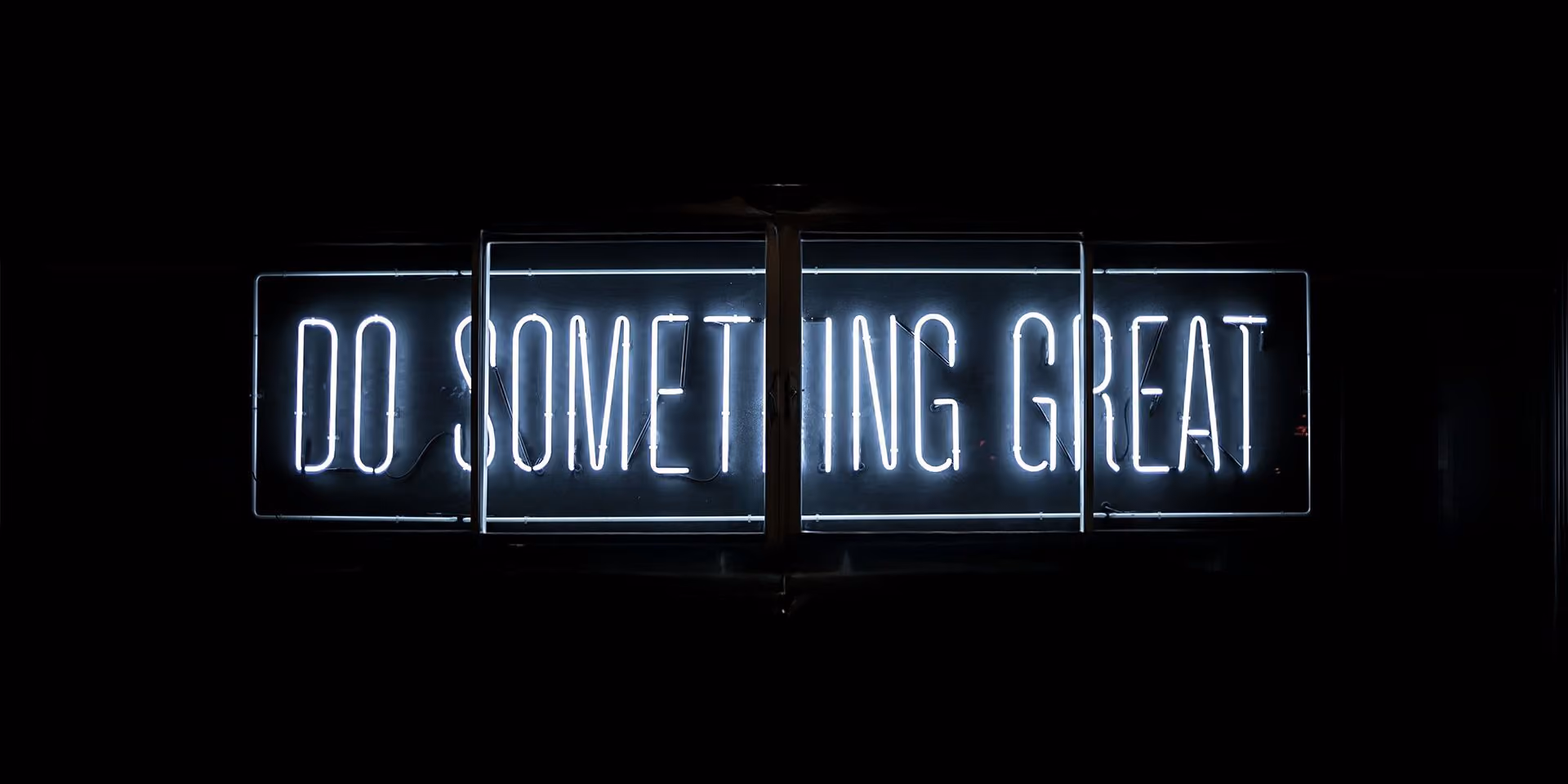 Neona gaismas zīme ar uzrakstu “DO SOMETHING GREAT”.