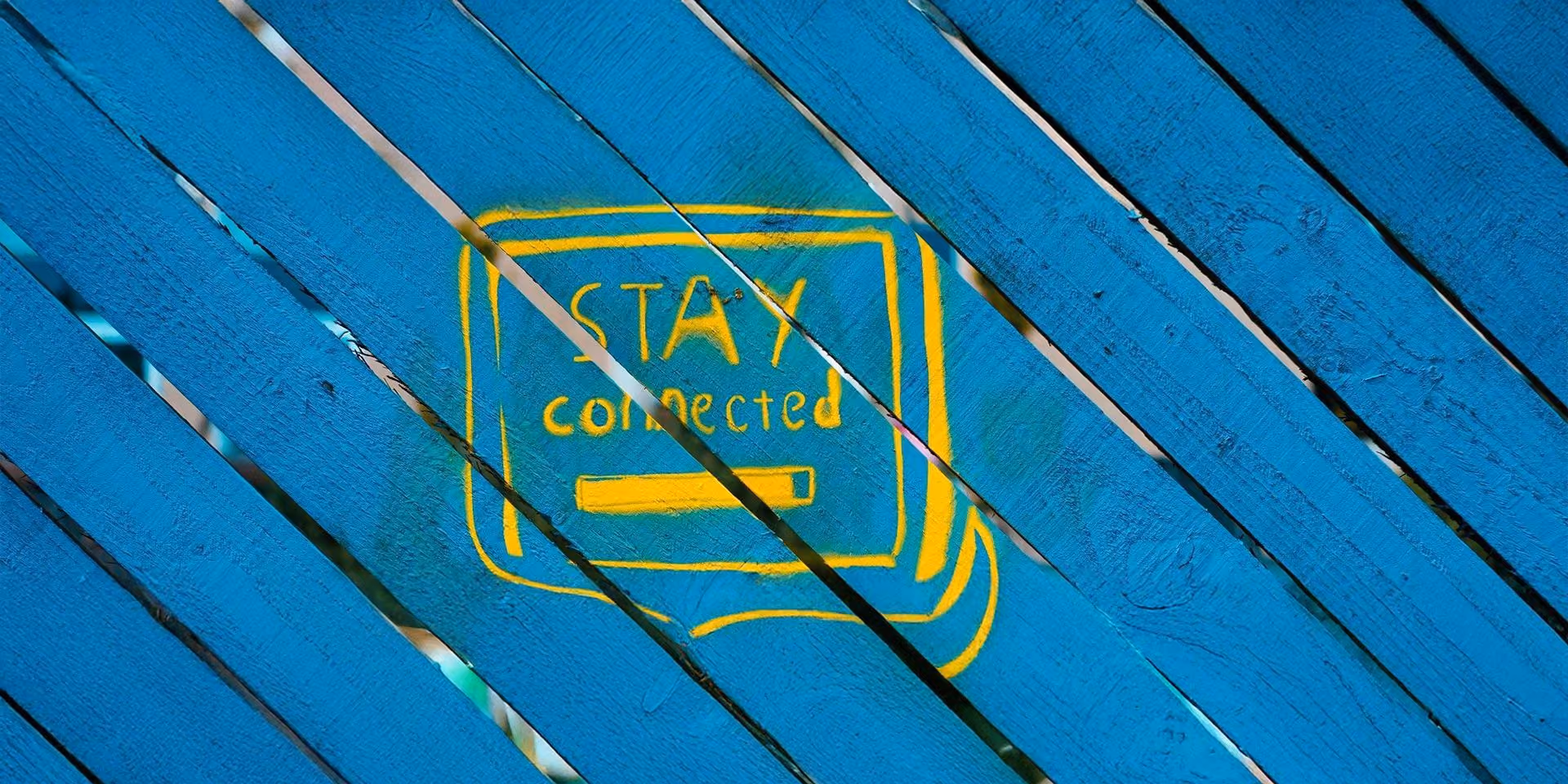 Zils koka dēlis ar uzrakstu “STAY connected” dzeltenā krāsā.