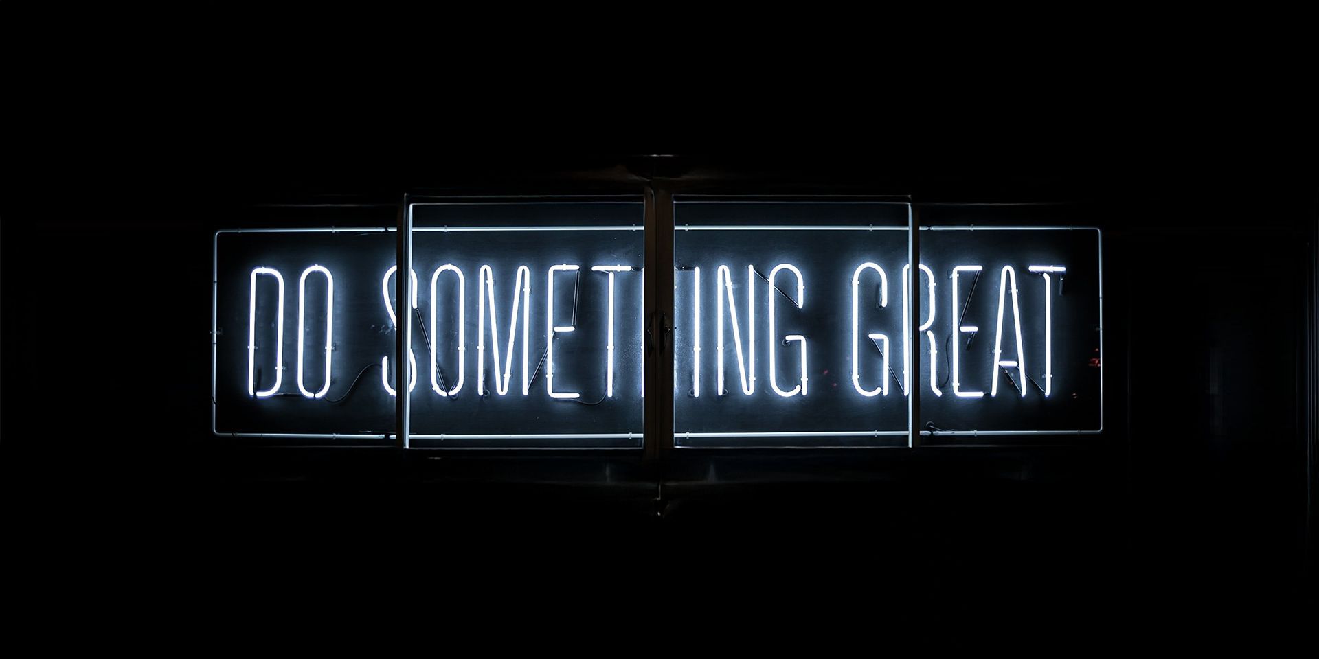 A neon light sign reading “DO SOMETHING GREAT”.
