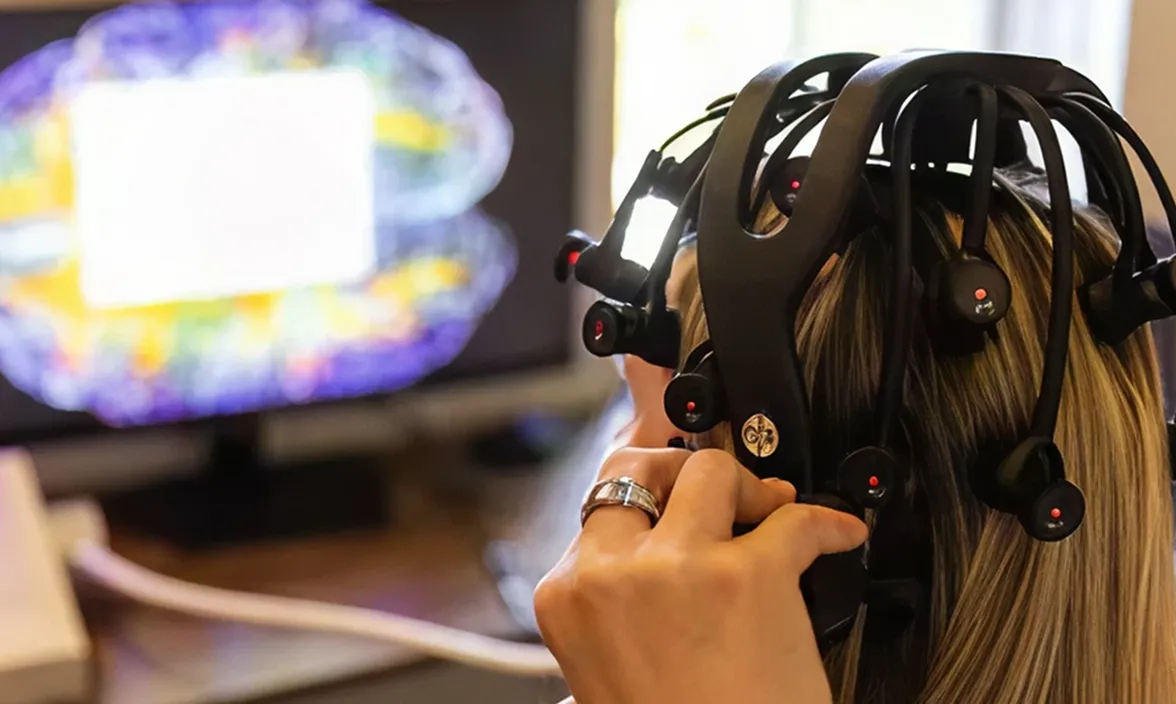 Practitioner placing a neurofeedback EEG headset on a patient