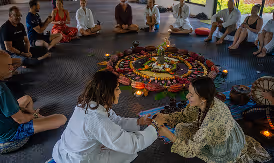 Retreat group sitting in a ceremonial circle around a flower mandala