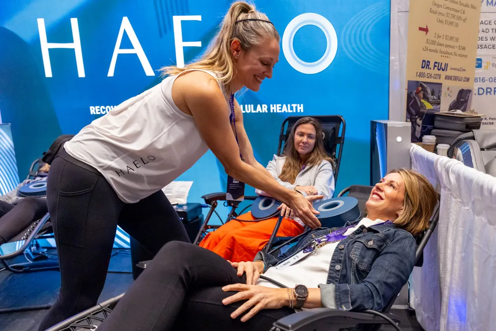 Attendees experiencing biohacking treatments at a conference booth