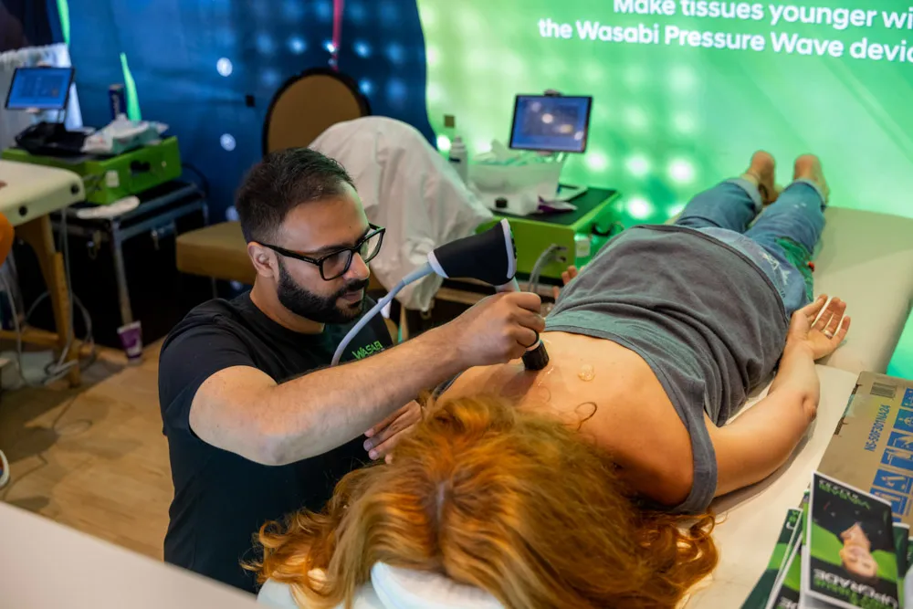 Practitioner performing a sound wave therapy treatment on a patient at the Biohacking Conference