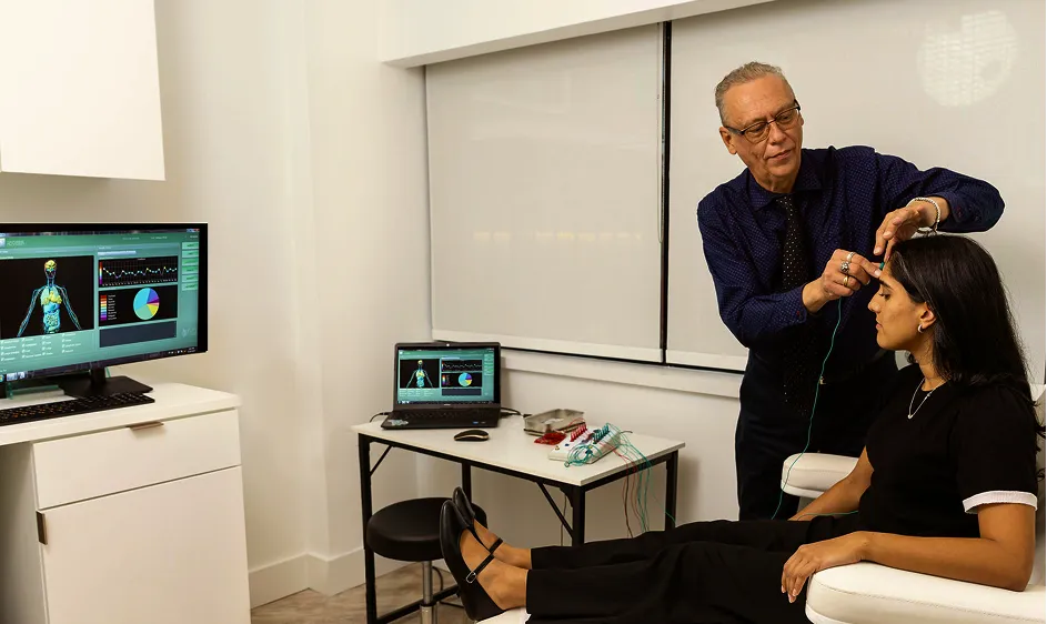 Practitioner performing a brain health assessment on a patient using biofeedback technology