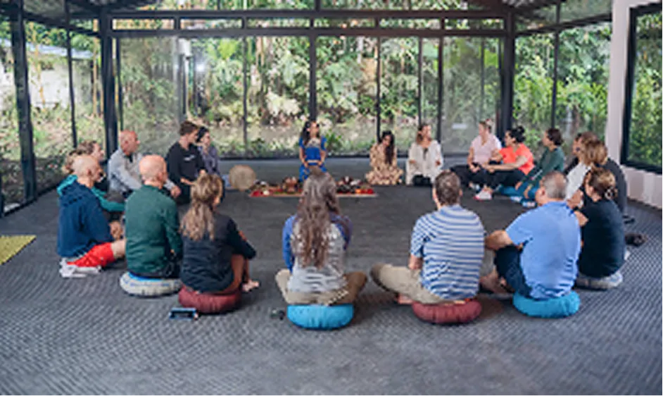 Group meditation session inside a modern glass wellness studio