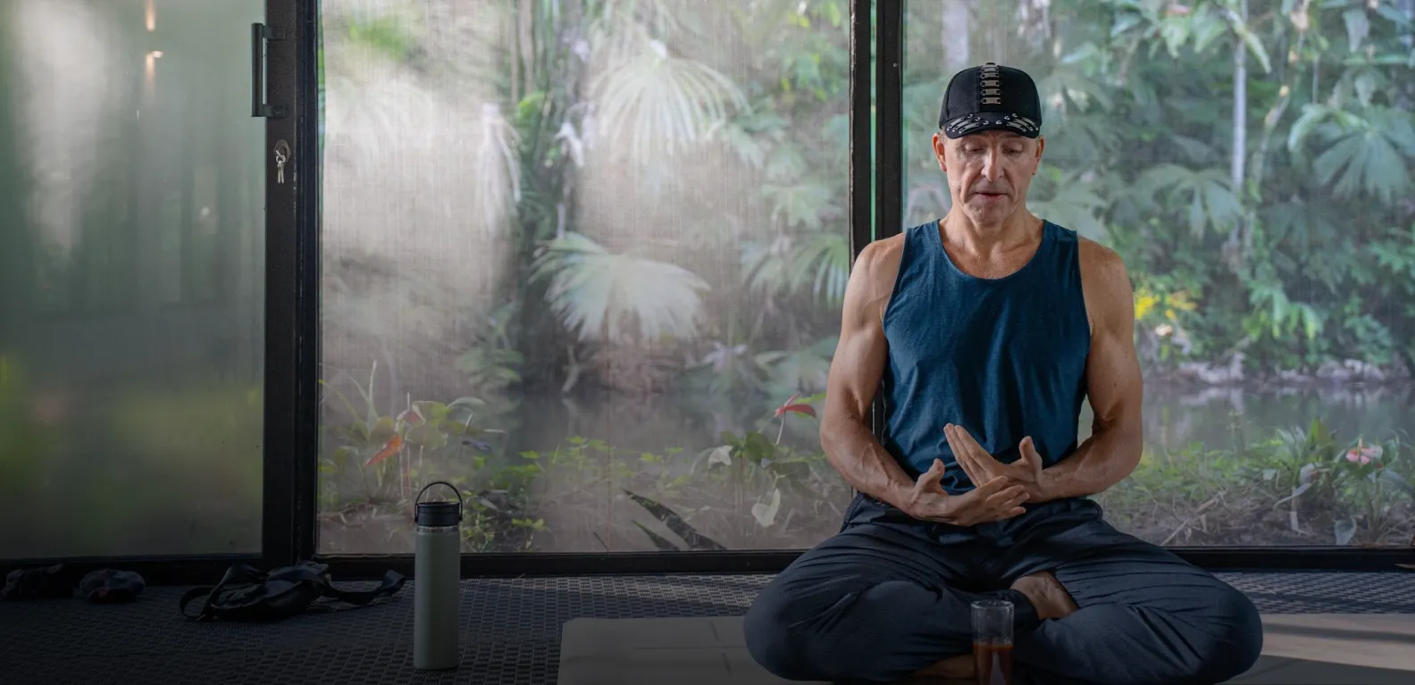 Marc Kielburger meditating in a tropical wellness retreat setting
