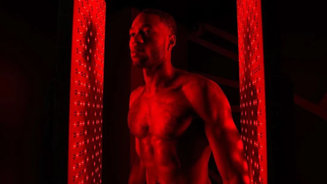 Person standing under red light therapy panels