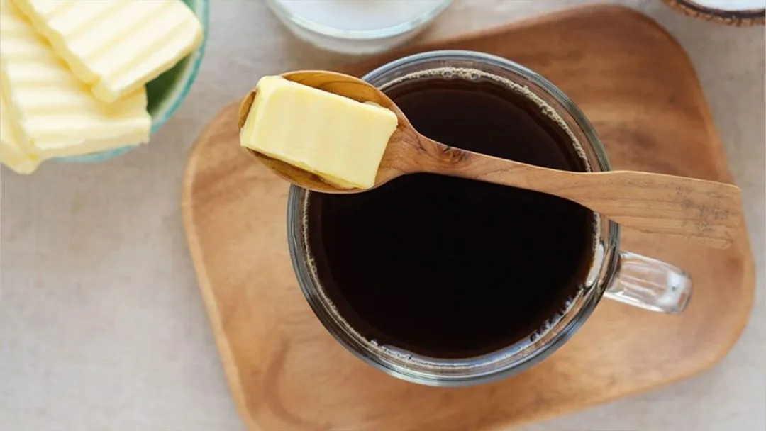 Bulletproof coffee with butter on a wooden board