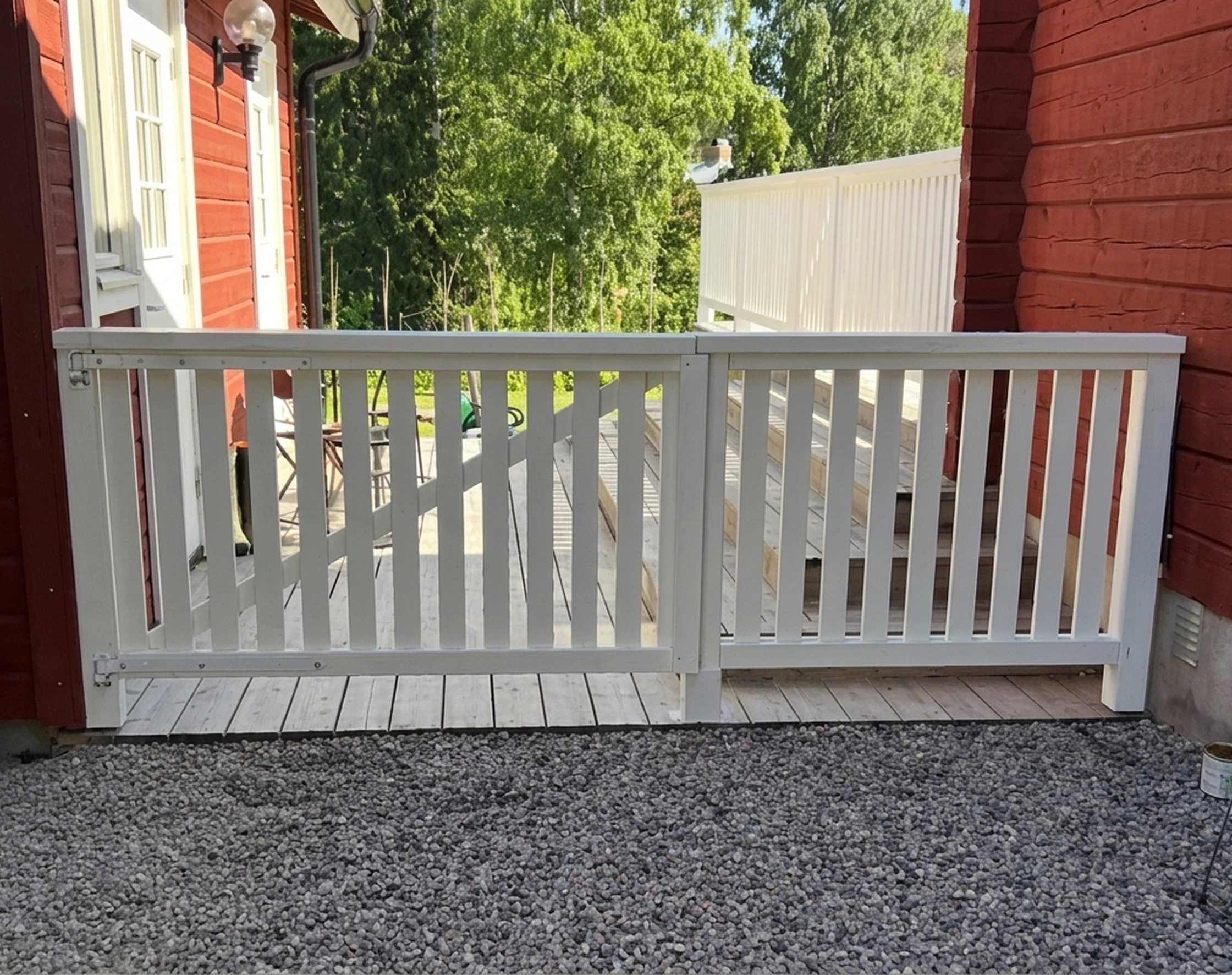Vitmålad grind med staket.
