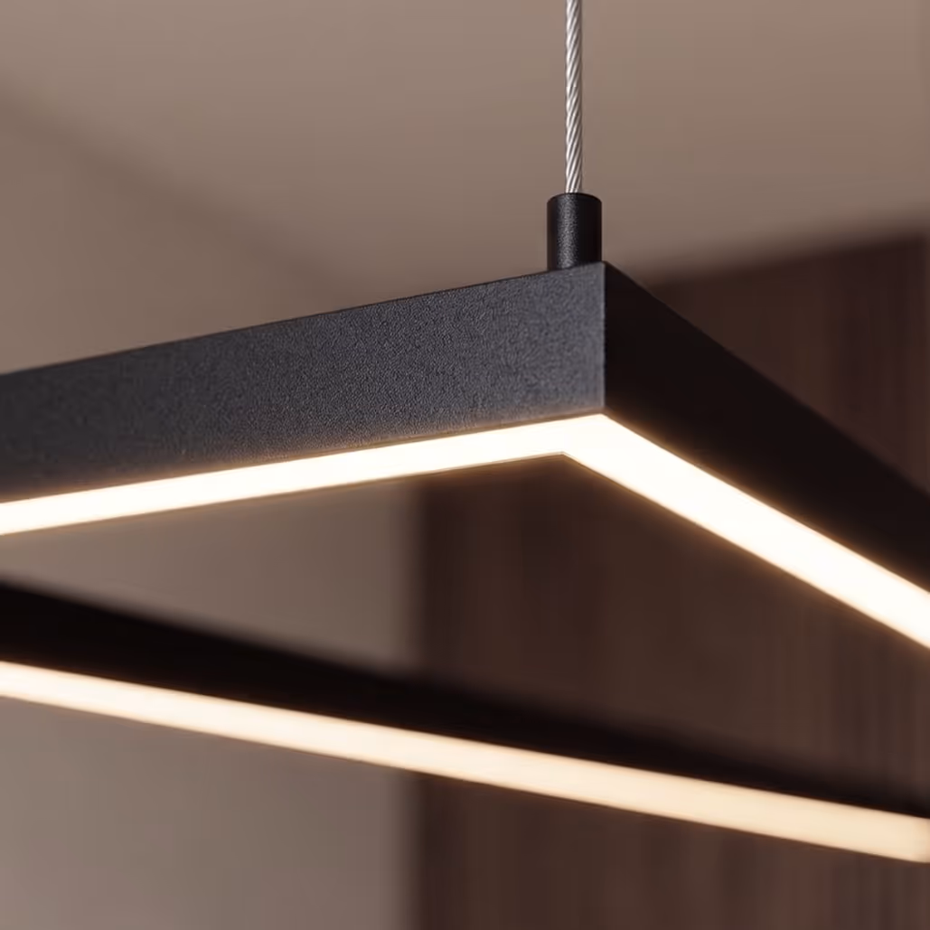 Black rectangular modern ceiling light fixture with glowing edges suspended by a cable.