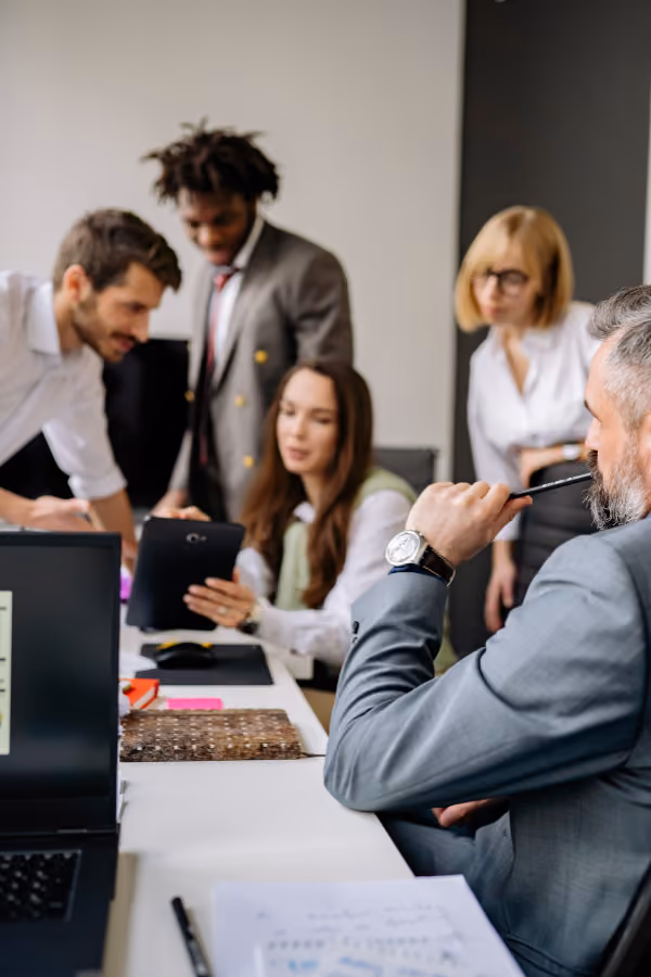 Group of professionals around a conference table looking at documents