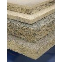 A stack of light-coloured boards with a fibrous structure visible on the cut edge