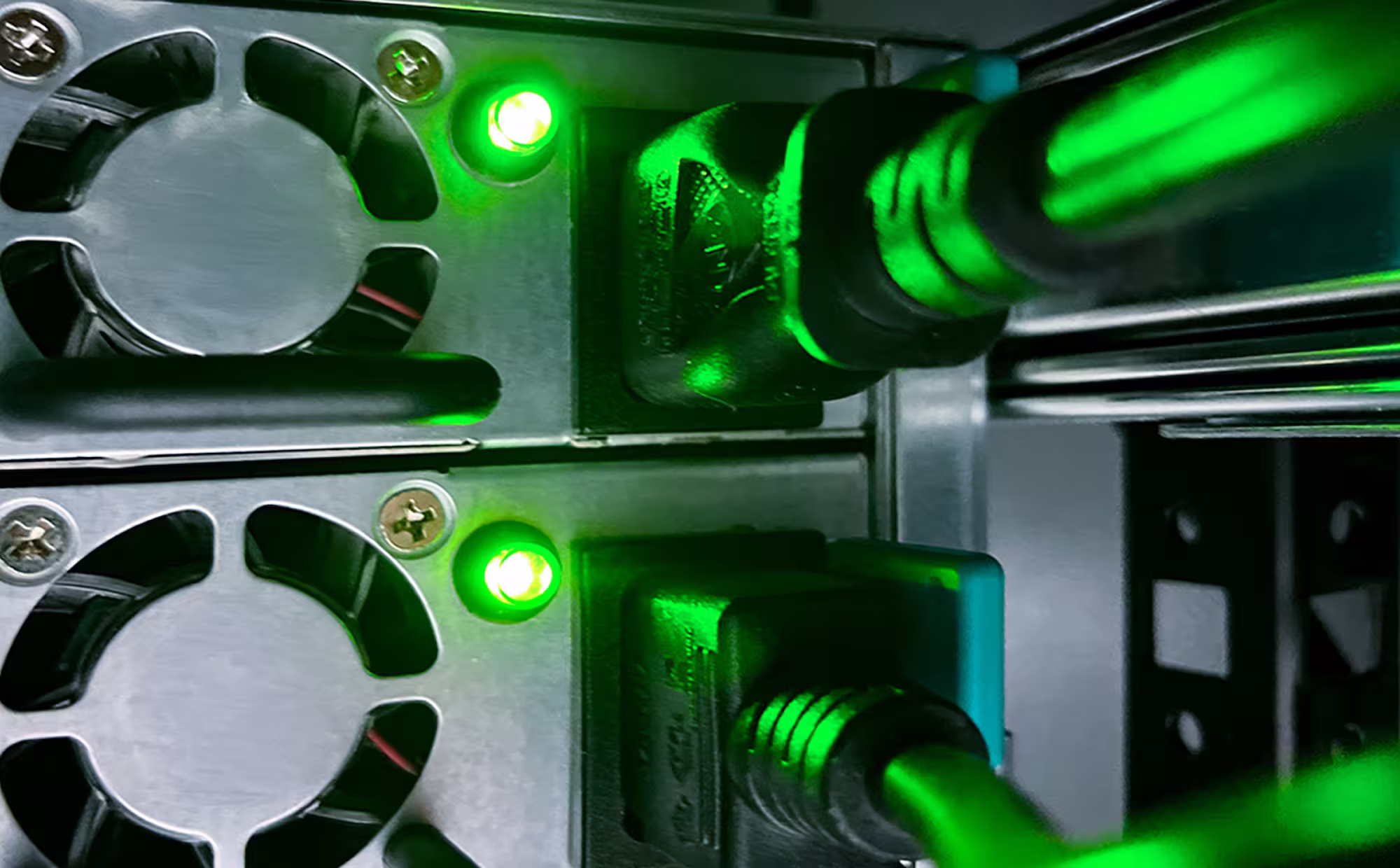 Close-up of two computer cooling fans and connected power cables with green indicator lights.