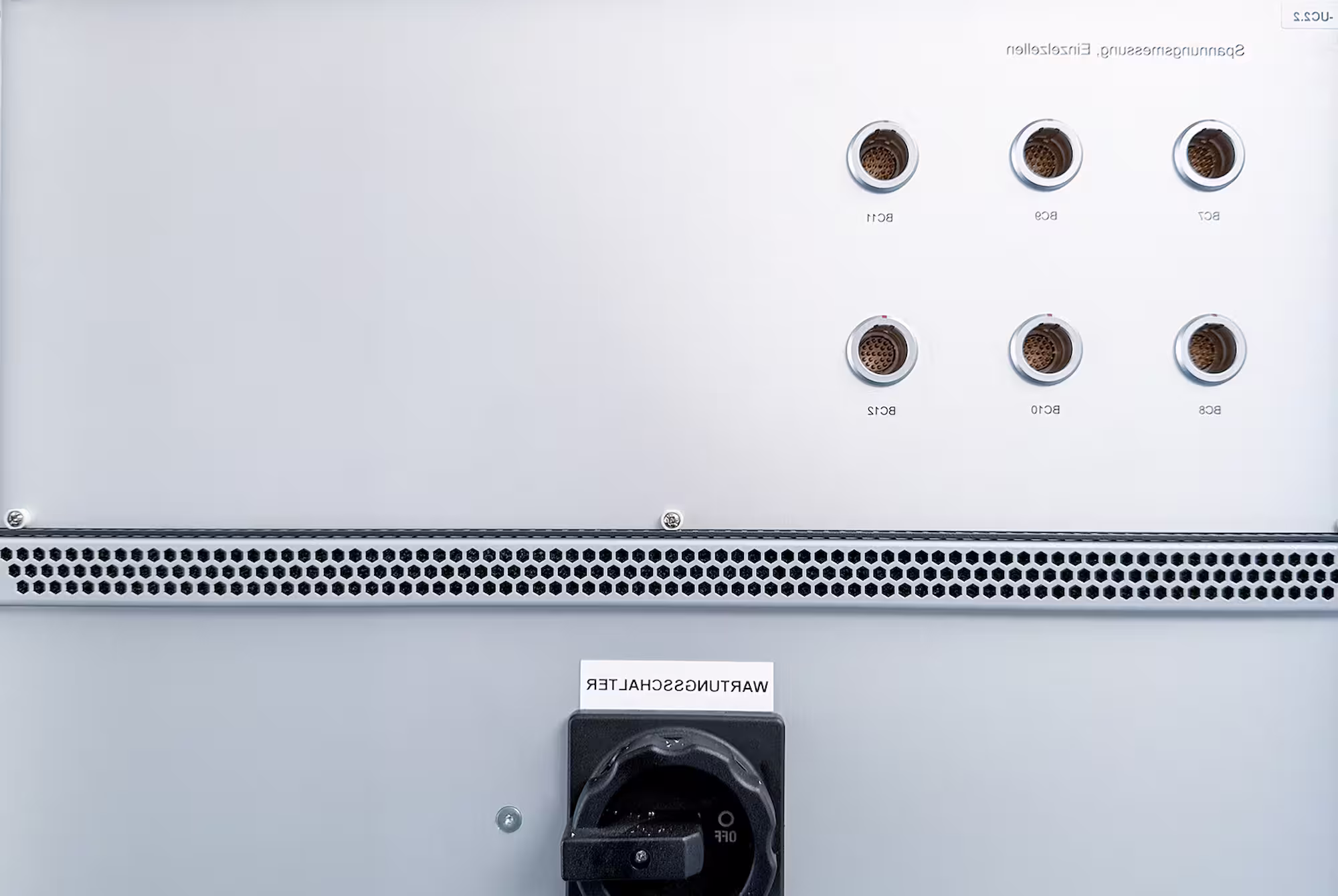 Close-up of an industrial battery testing control panel with round connectors and a black switch.