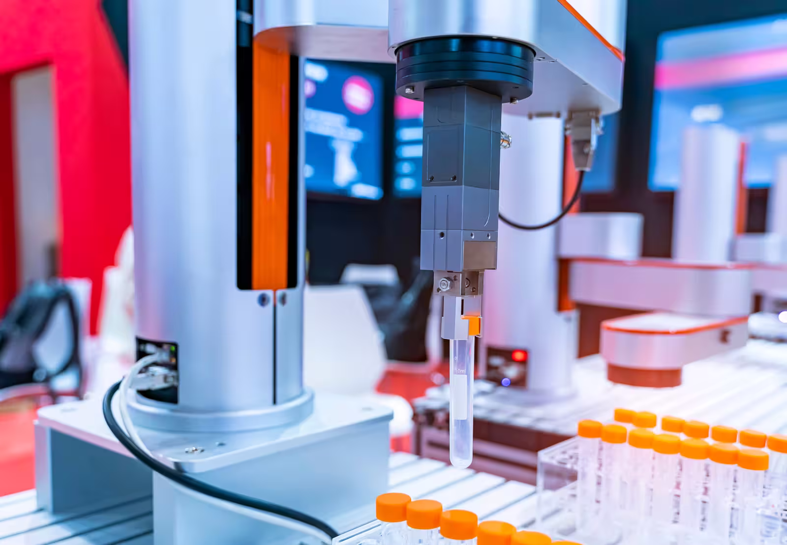 Automated lab robot handling a test tube among many orange-capped tubes in a scientific setting.