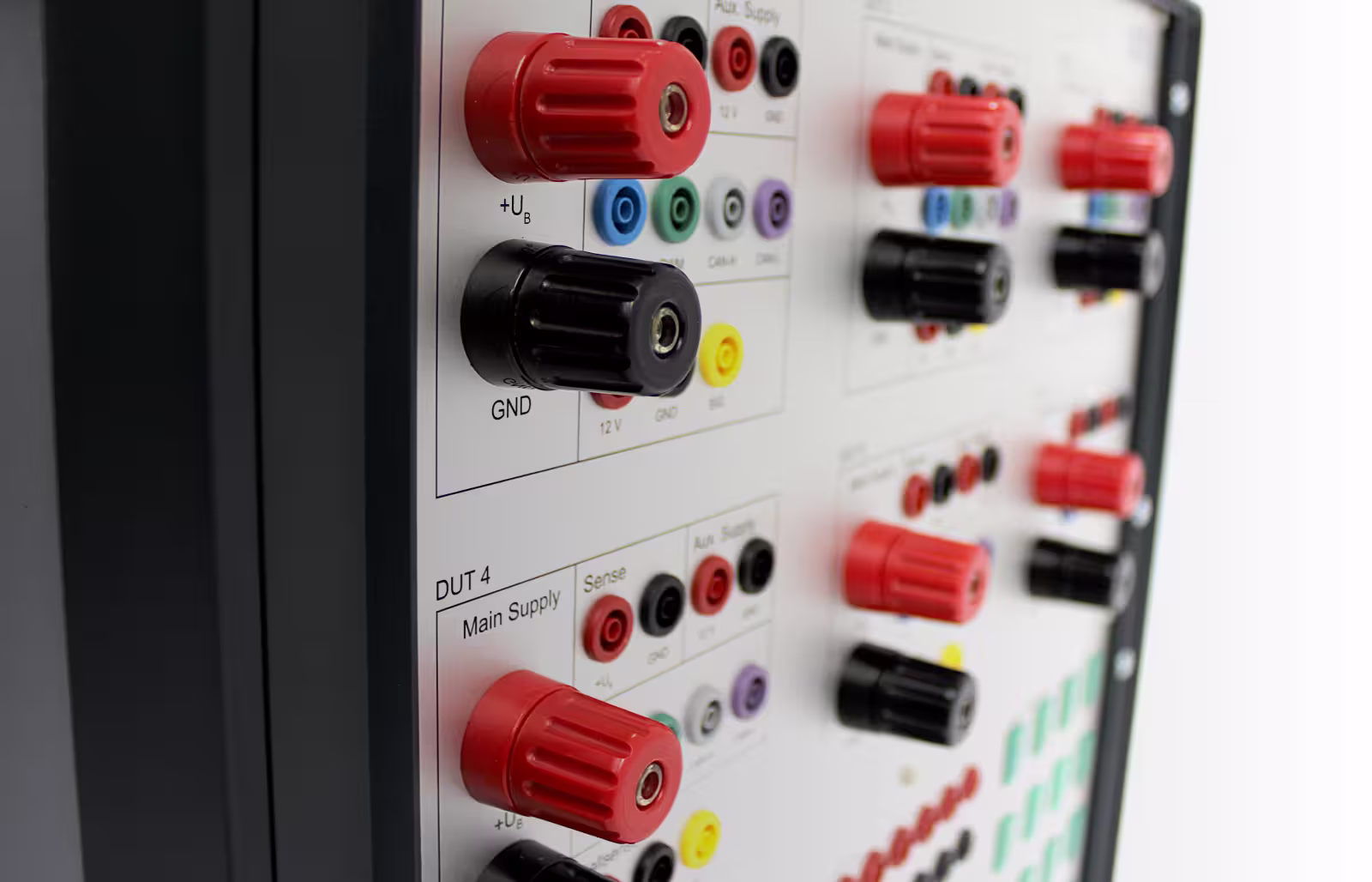 Close-up of an electrical testing panel with red and black terminal connectors and labeling.